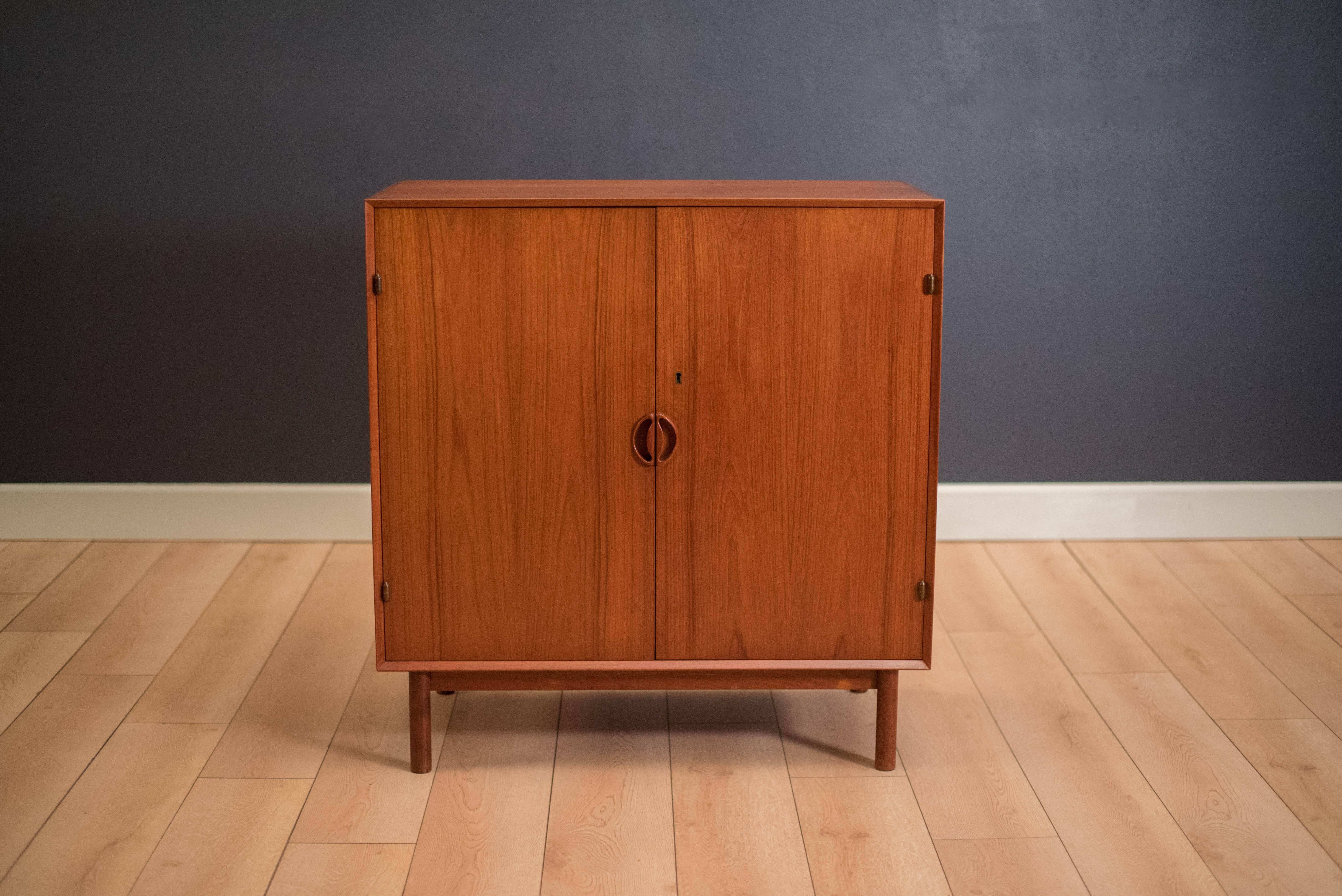 Mid-Century teak cabinet by Peter Hvidt and Orla Molgaard-Nielsen for Soborg Mobelfabrik. This piece displays detailed finger joinery and sculpted wood handles. Interior of cabinet features three sliding drawers and one adjustable shelf. Skeleton