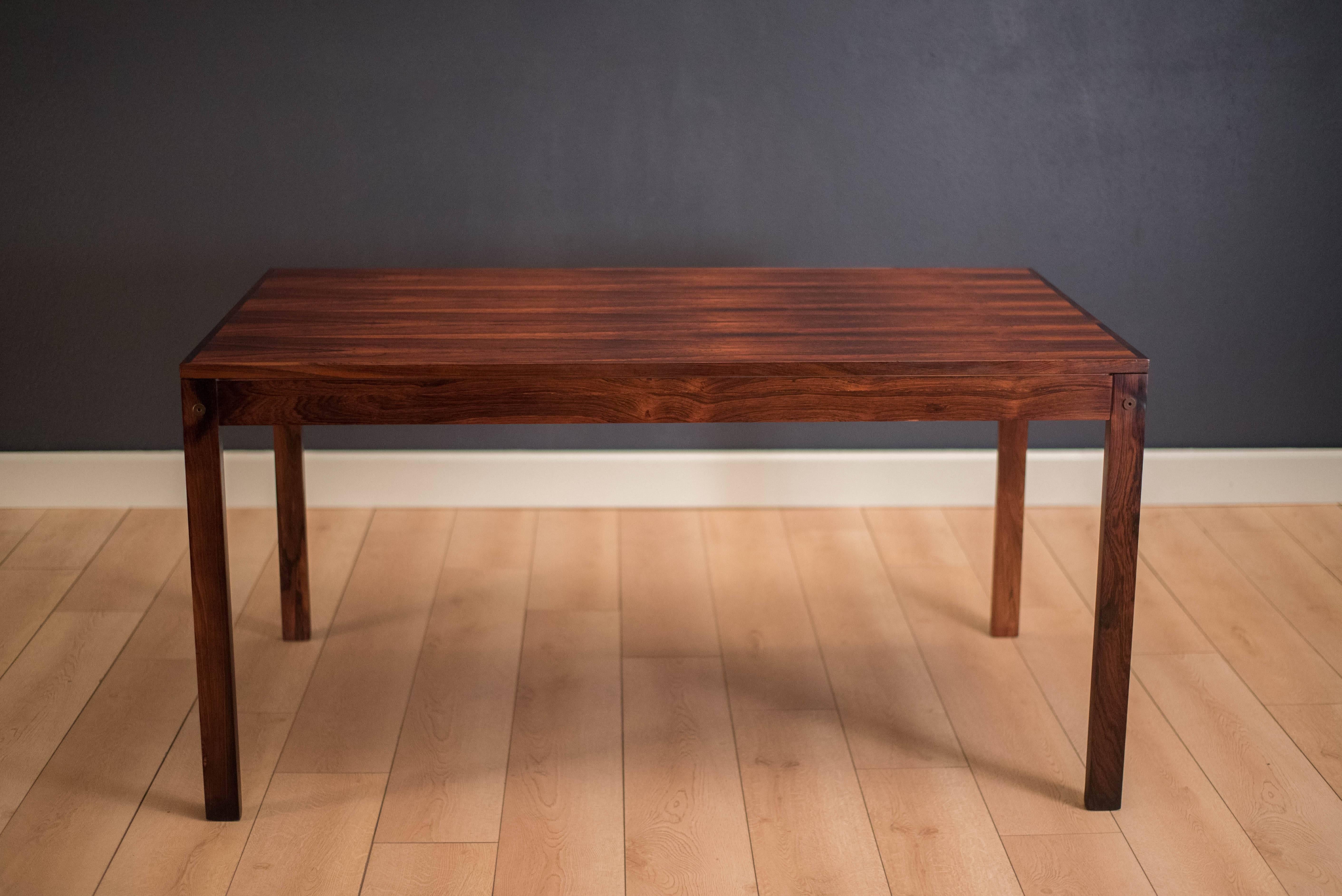 Vintage Danish dining table in rosewood, circa 1970s. This piece expands with one extension leaf that stores underneath top. 

Dimensions: 88.5