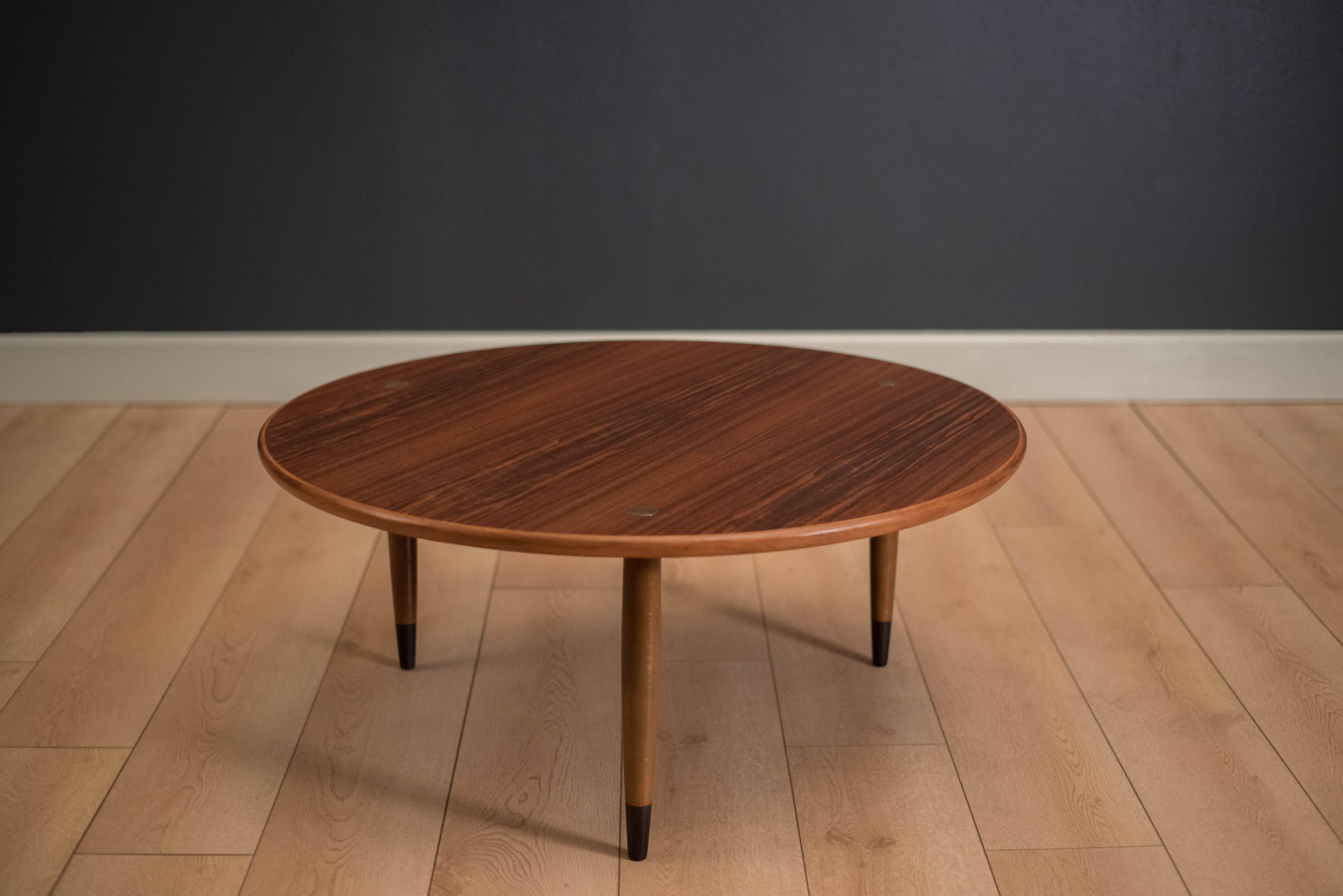 Mid-Century Modern round coffee table in walnut by DUX of Sweden. This piece features brass accents and a solid walnut edge banding.