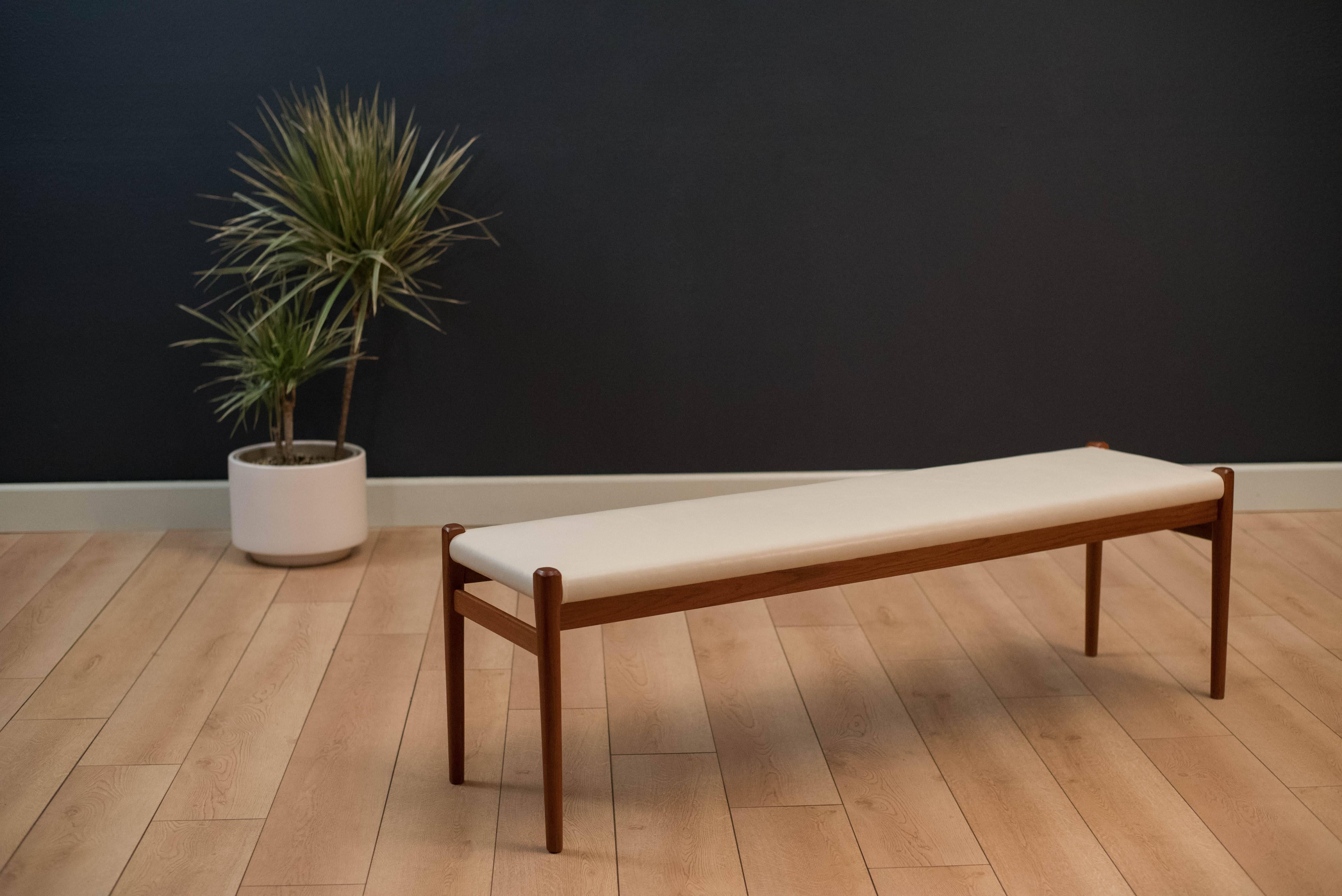 Vintage Danish bench in teak by Niels Moller for J.L. Mobelfabrik, Denmark. This piece has been newly reupholstered in white leather and functions as dining seating or as a hallway/bedroom bench.