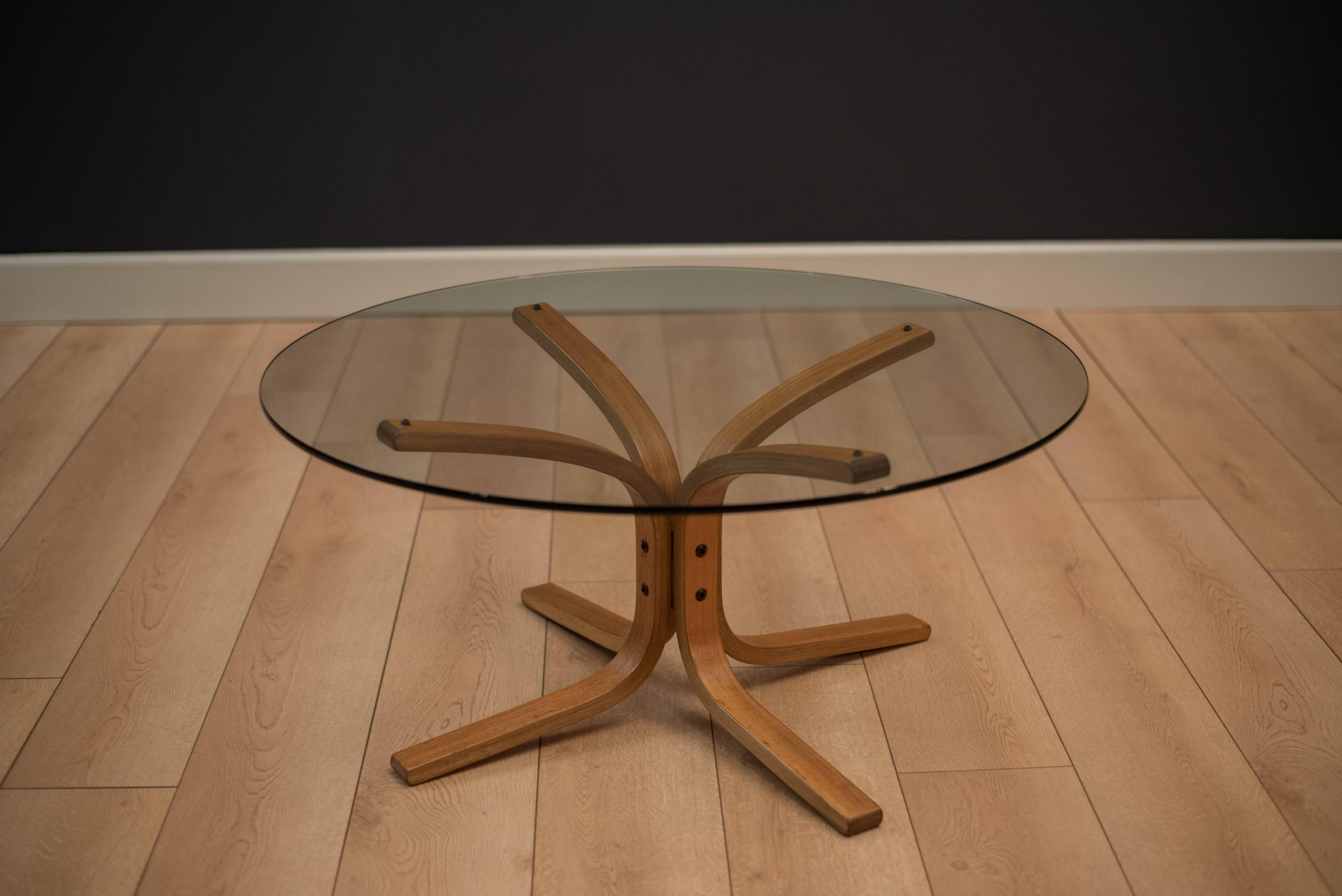 Mid-century glass and teak coffee table designed by Ingmar Relling for Westnofa. This piece features a unique teak bent plywood base and includes a 3/8