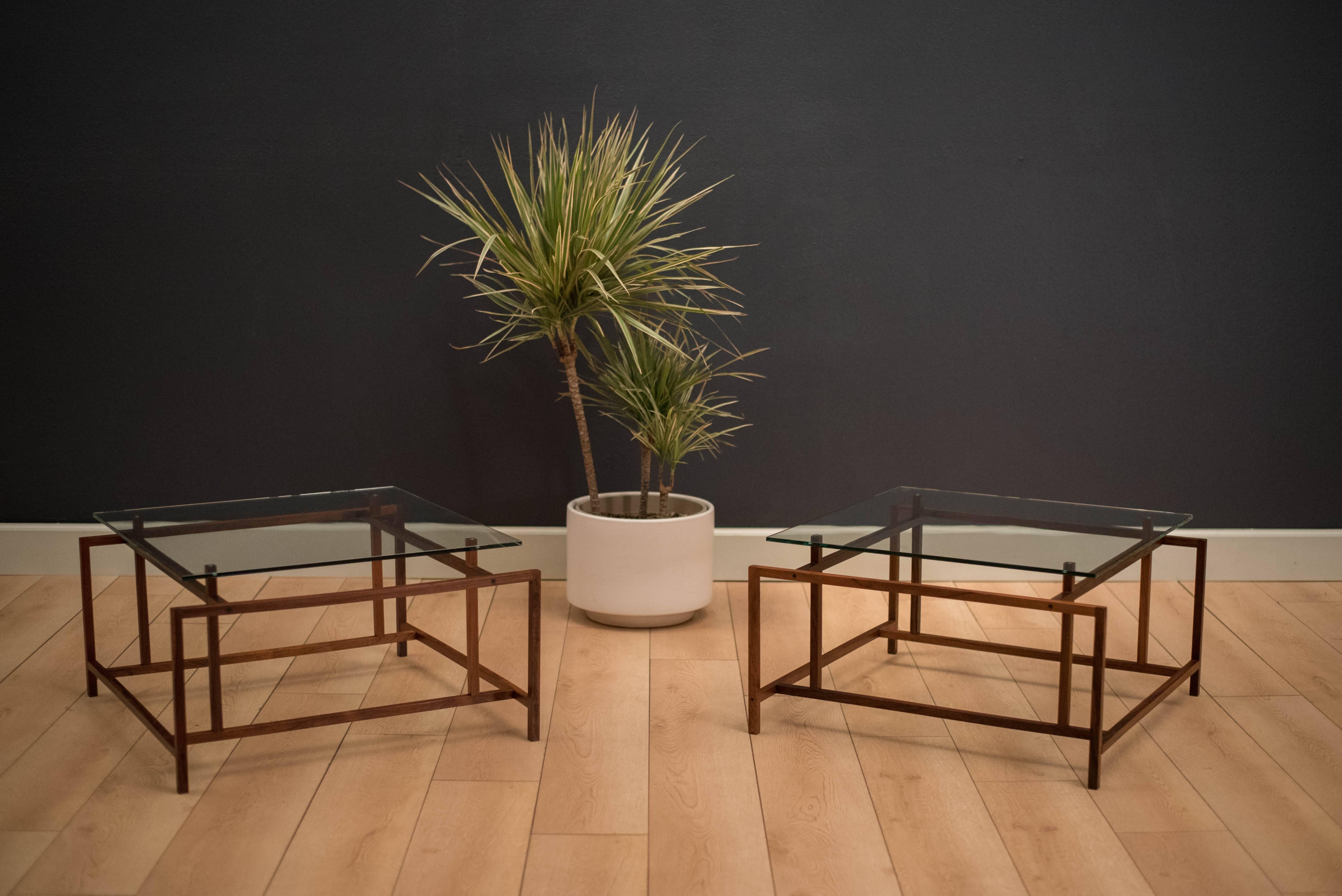 Mid Century glass side tables designed by Henning Norgaard for Komfort. These unique floating tables display a geometric design with rosewood bases. Price is for the pair. 

Glass top is 3/8