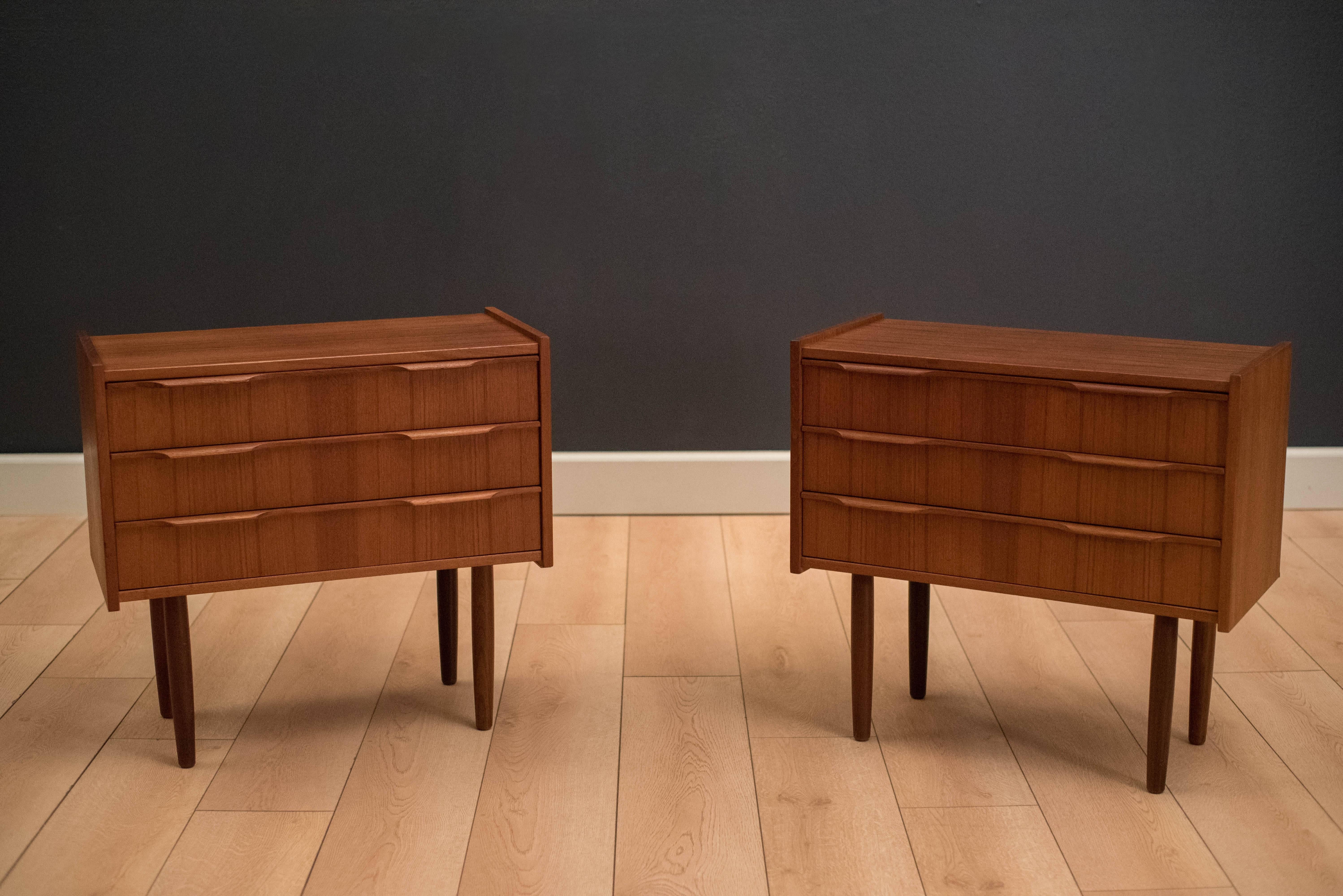 Midcentury teak nightstands manufactured by Ejsing Mobelfabrik, Denmark. This matching set includes three dovetailed drawers with sculpted handles. Price is for the pair. 

  