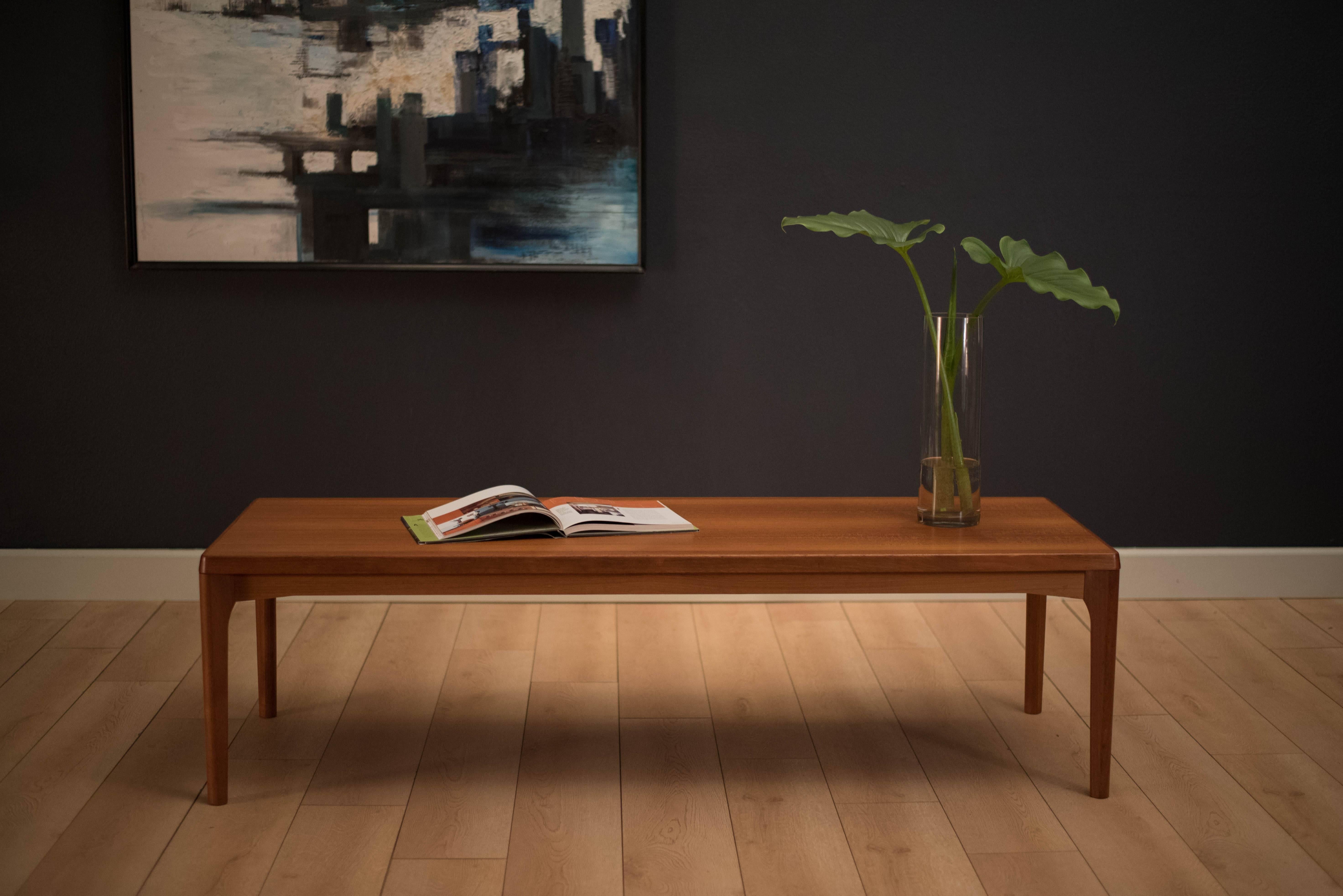 Mid century coffee table designed by Henning Kjaernulf for Vejle Stole-og Mobelfabrik in teak. This piece displays sleek angled tapered legs and a long rectangular table top.
