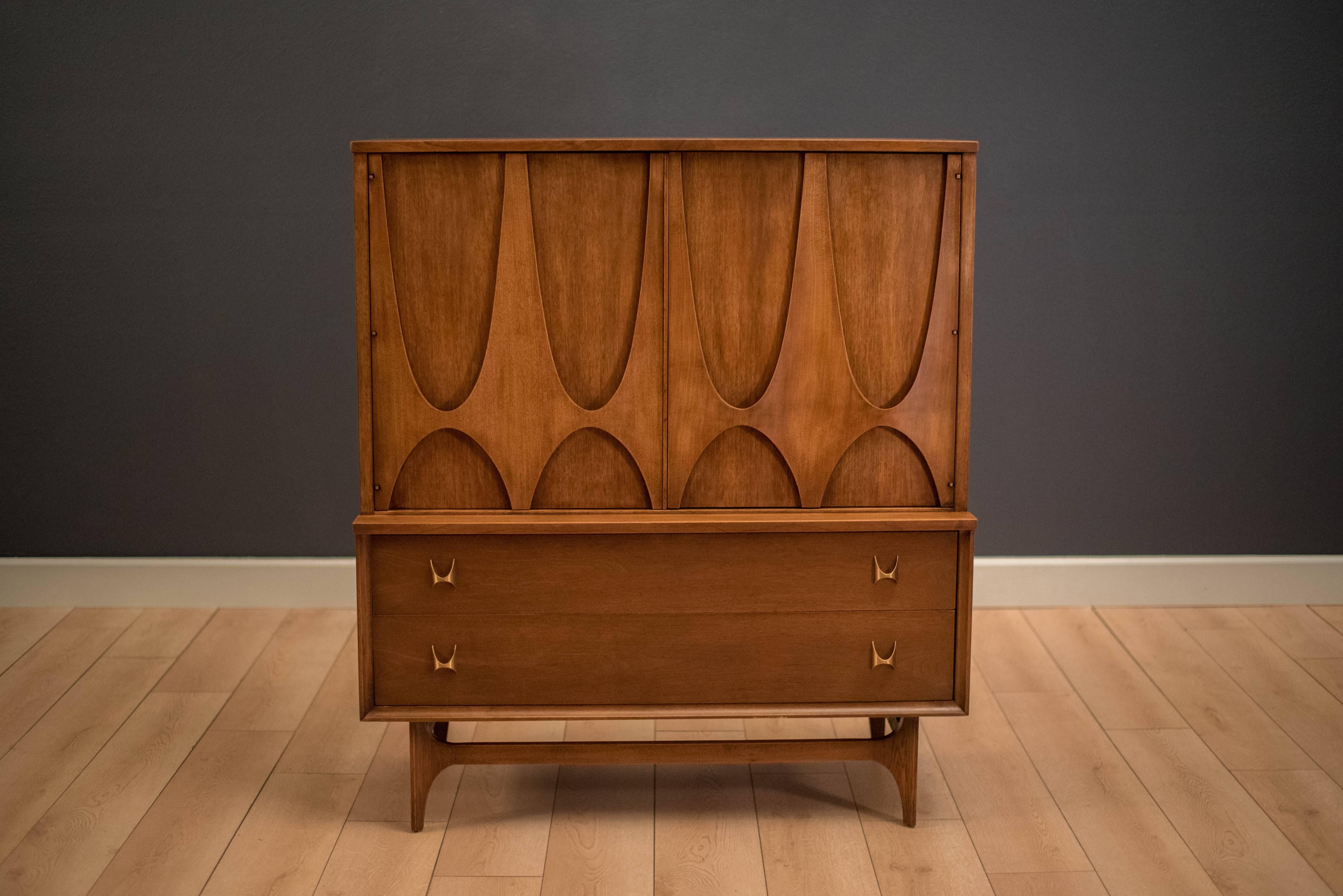 Mid-century highboy door chest from the Broyhill Brasilia line, circa 1960s. This piece is equipped with two lower dovetailed drawers accessorized with signature brass handles. Includes open storage with two fixed shelves and four additional drawers