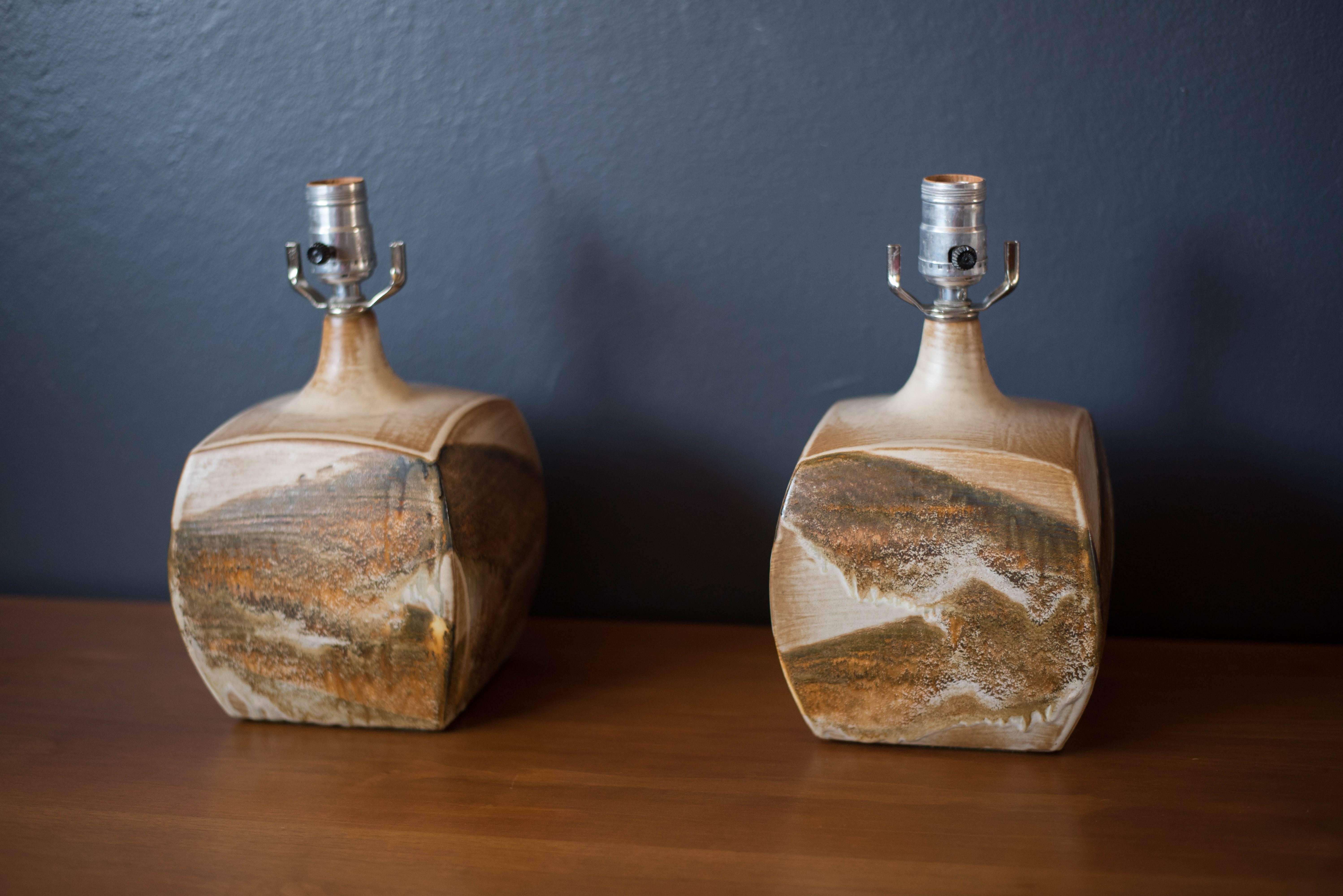 Mid-Century Modern studio ceramic pottery lamps, circa 1970s. This pair displays a desert sand palette with bisque, ivory, and beige tones in a drip glaze matte finish. Price is for the set of two.