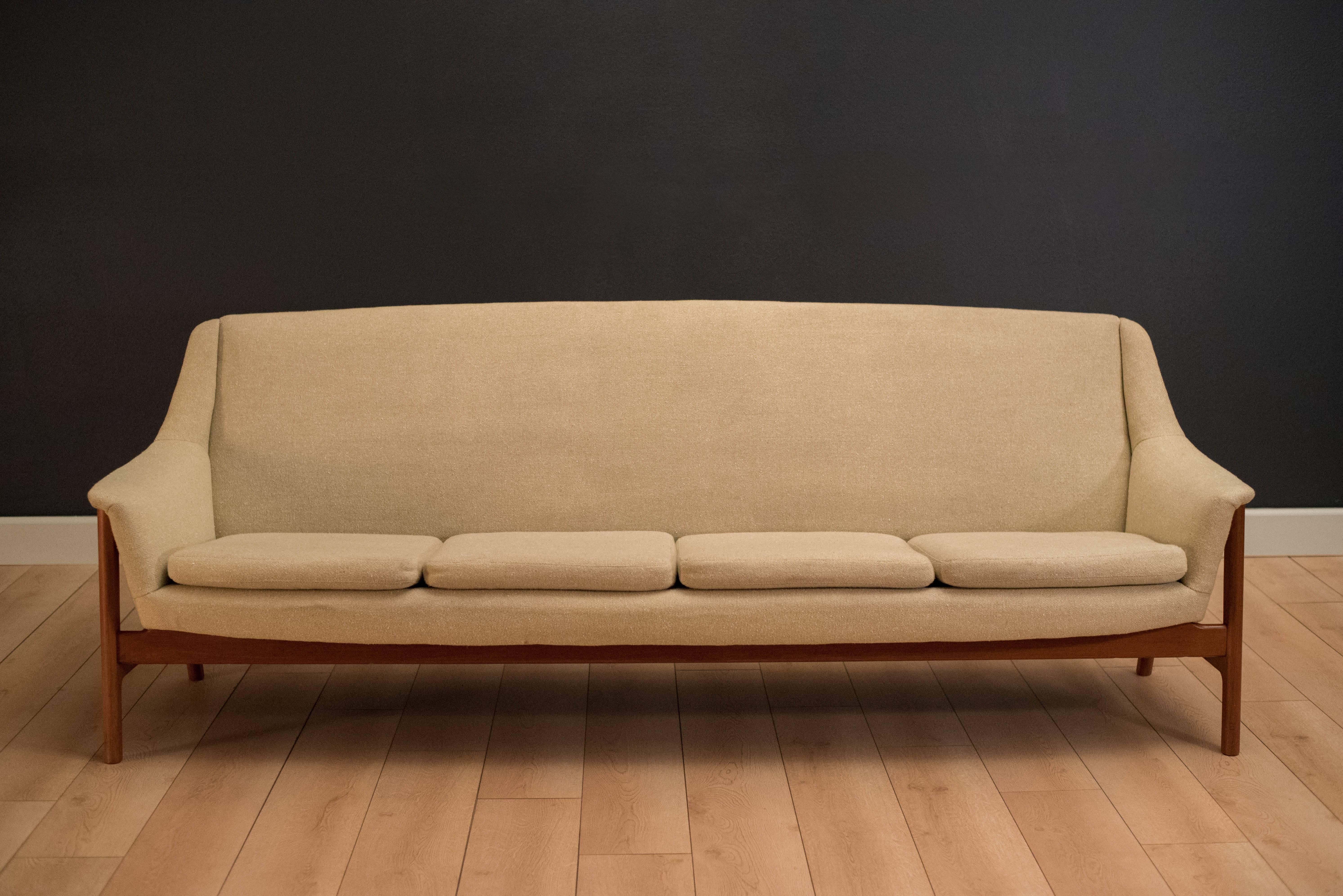 Mid-Century Modern four seat sofa by DUX, Sweden. This piece features external splayed teak legs with a cream colored tweed fabric.