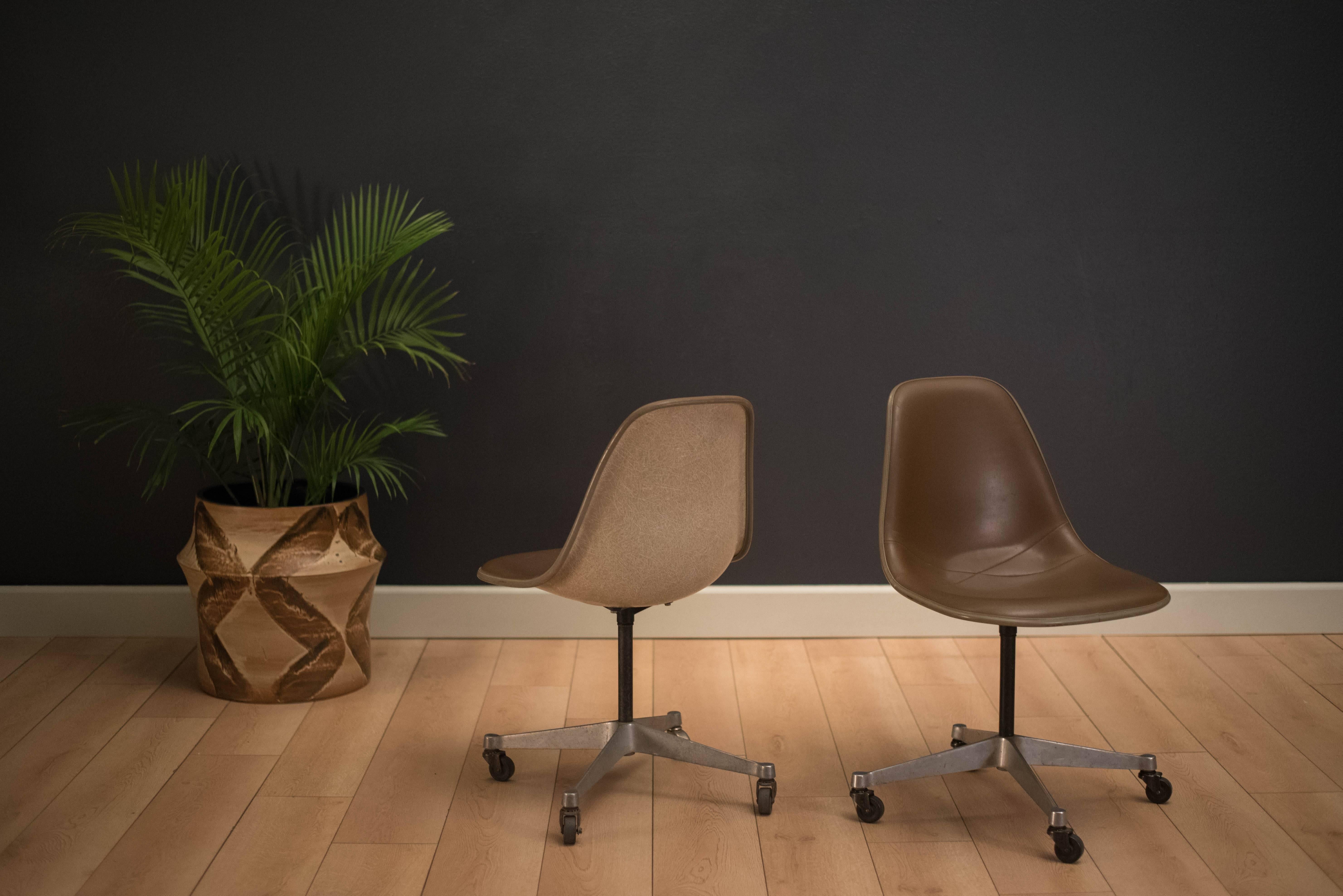 Mid-Century Modern office shell chairs designed by Ray and Charles Eames for Herman Miller. Includes the original brown vinyl padded seat with aluminum swivel base on rolling casters. Price is for each chair. 