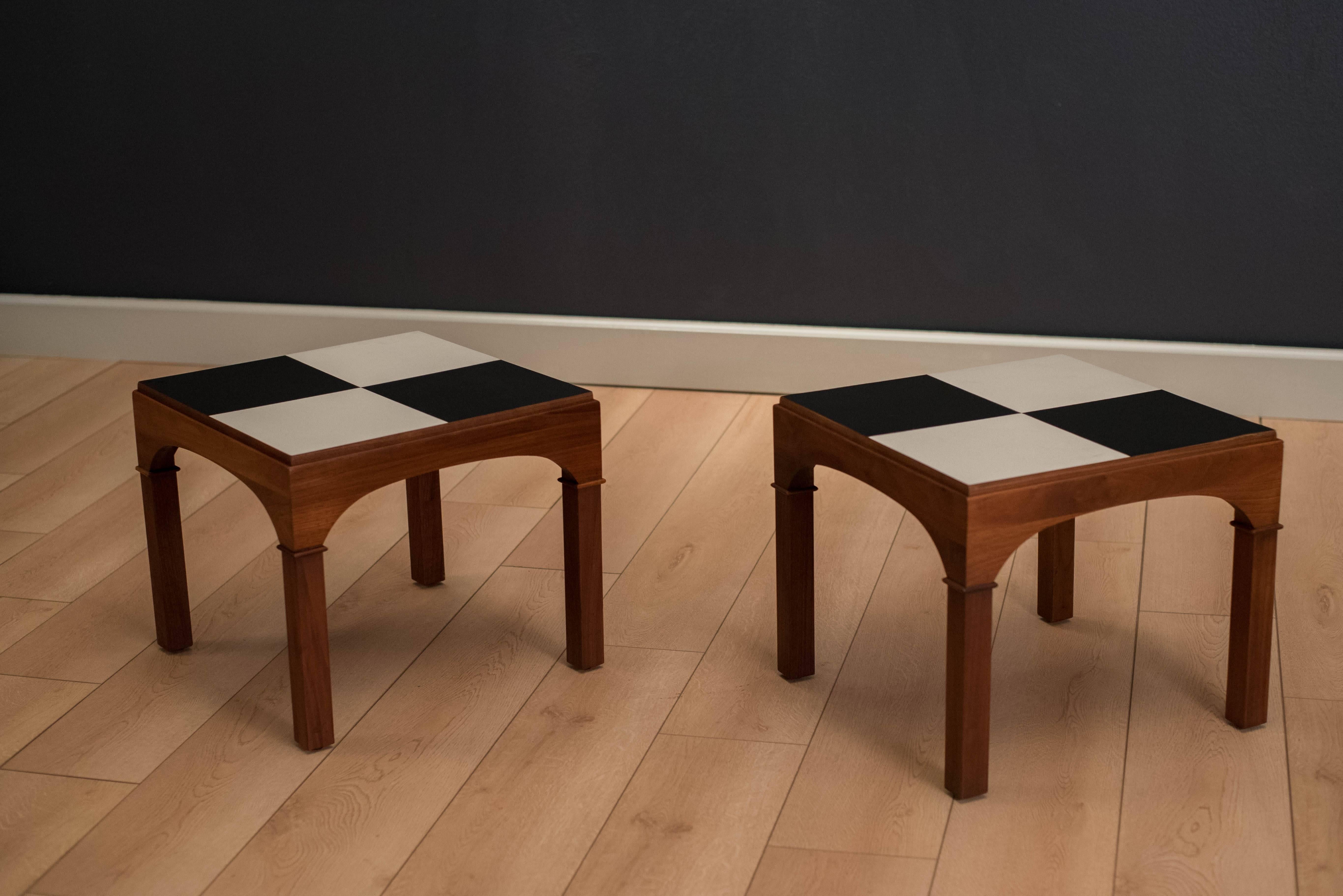 Mid-Century Brown Saltman end tables designed by John Keal, circa 1950s. This rare set features a checkered black and white formica top on a solid walnut base. Price is for the pair.