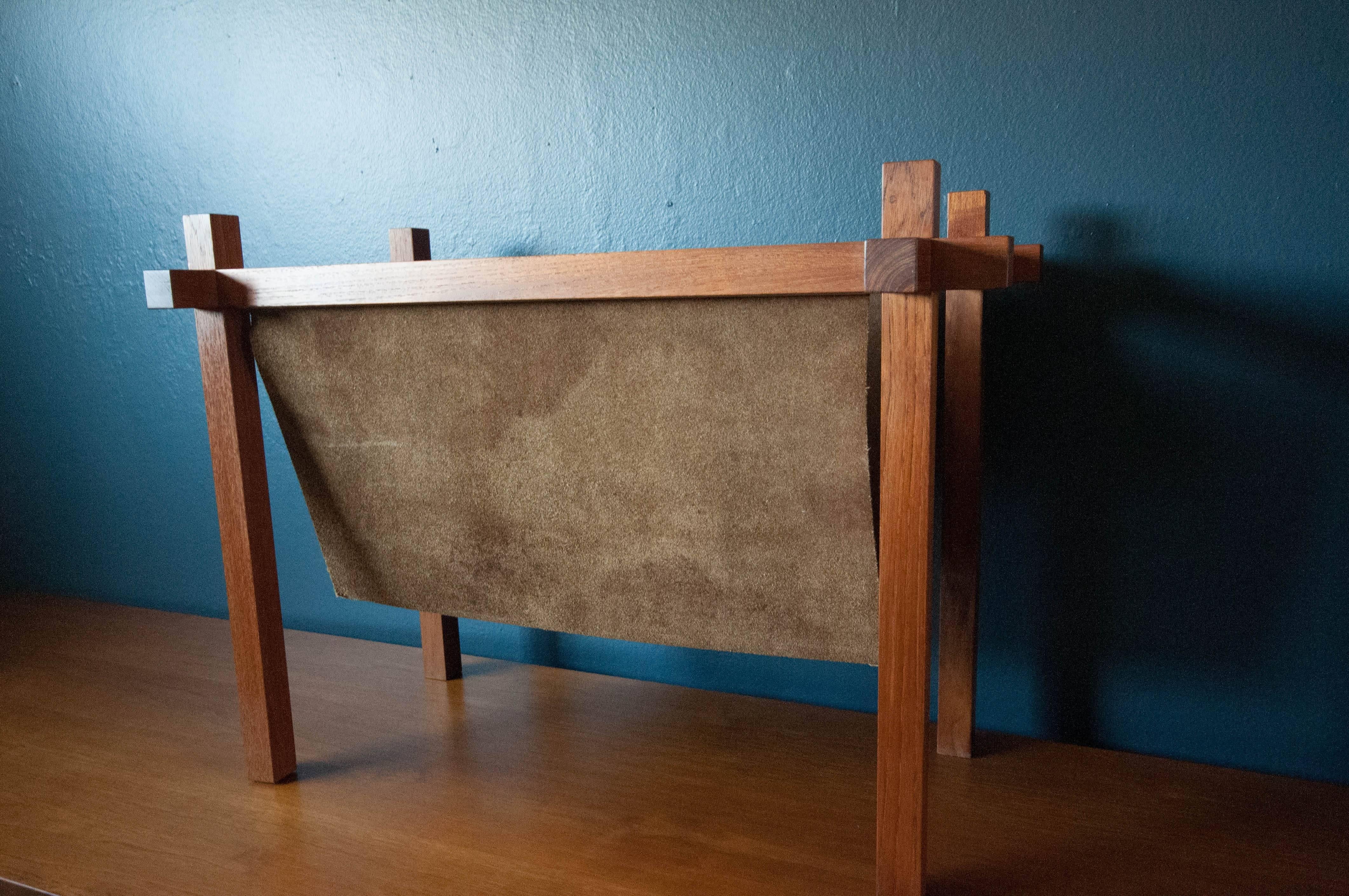 Danish magazine rack by Skjode Skjern in solid teak and leather. This rare piece displays clean modern lines and is in great condition with minimal vintage wear. 

 