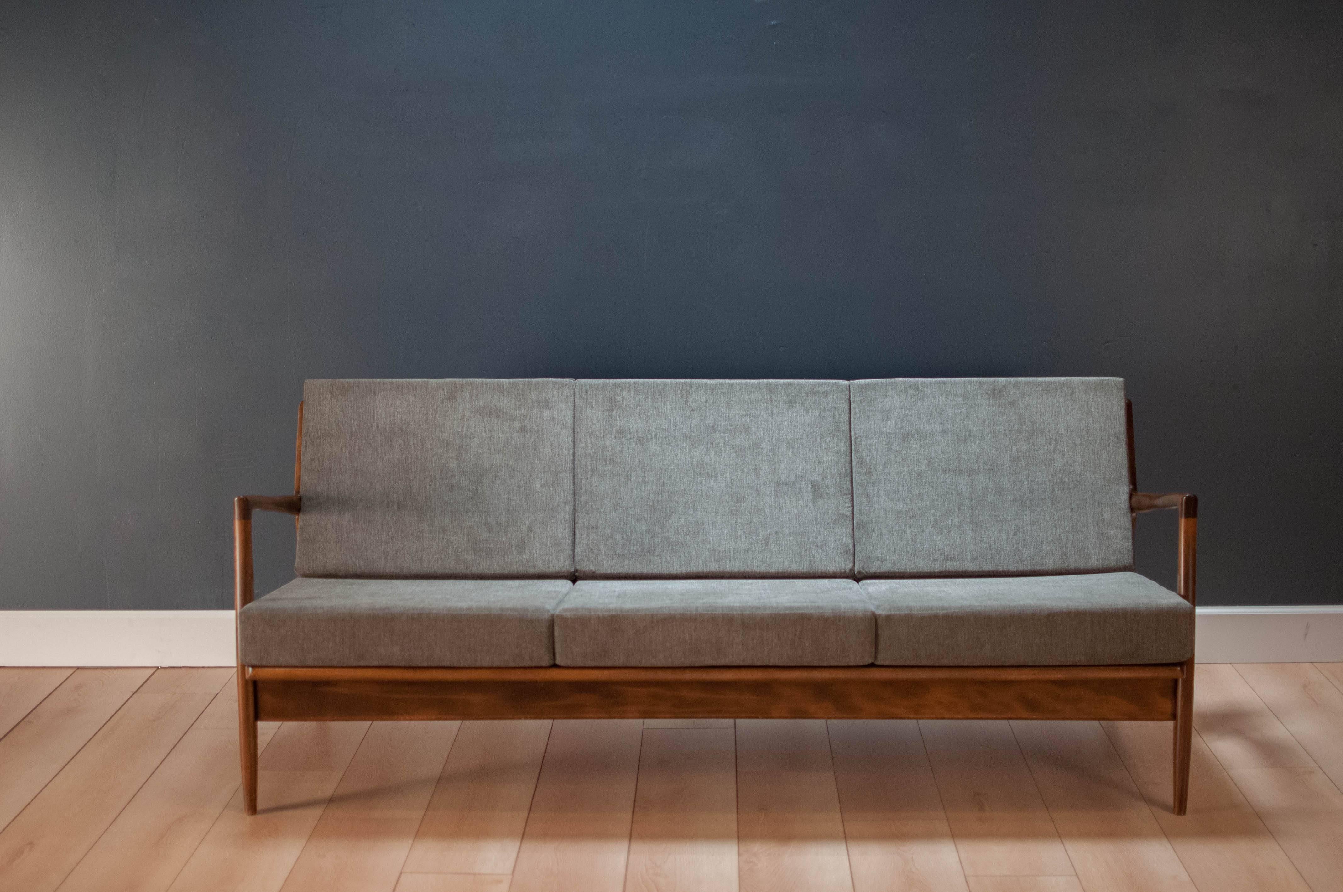 Danish Classic Ib Kofod-Larsen sofa by Selig. This piece has been newly reupholstered in a medium gray fabric.

 