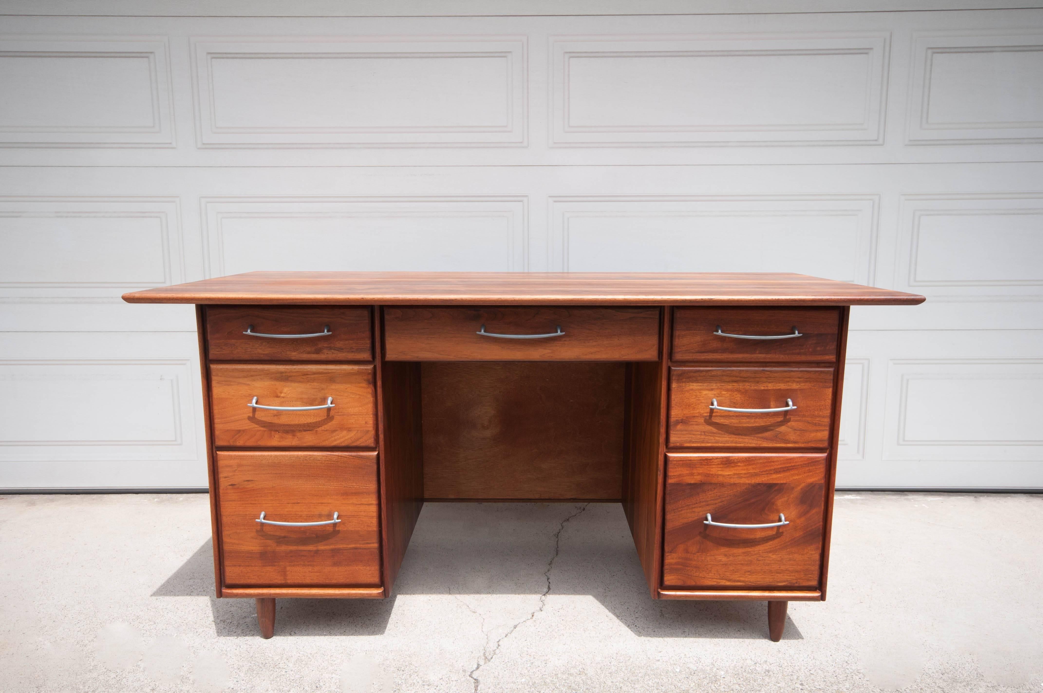 Mid-Century Ace-Hi Desk in solid walnut. This desk offers plenty of storage space complete with seven spacious drawers accessorized with pewter handles. 
 
