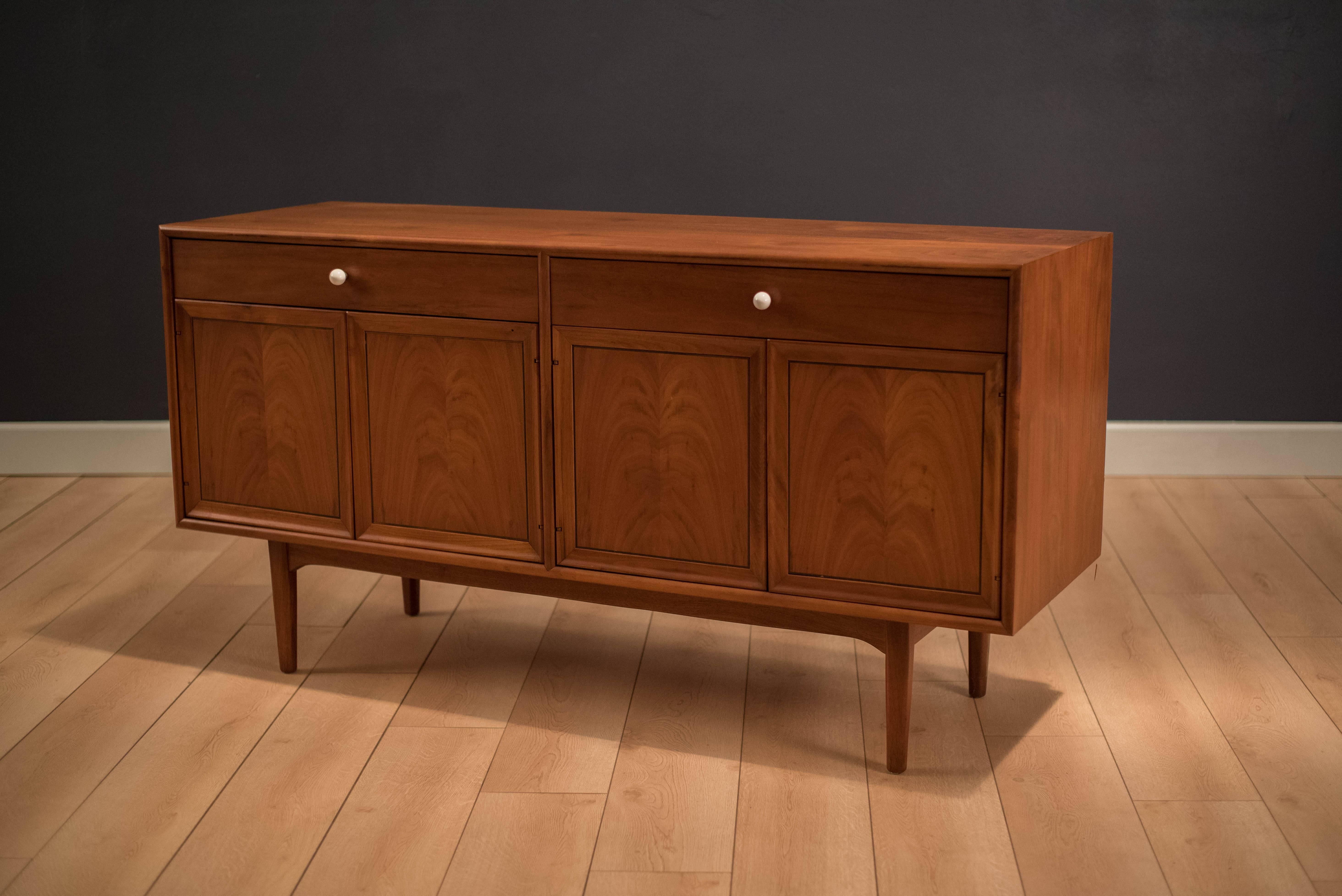 Mid Century Drexel Declaration Buffet Credenza by Kipp Stewart and Stewart McDougall. This piece features bookmatched black walnut grains highlighted by their signature white porcelain pulls. Equipped with two drawers and adjustable open shelving.