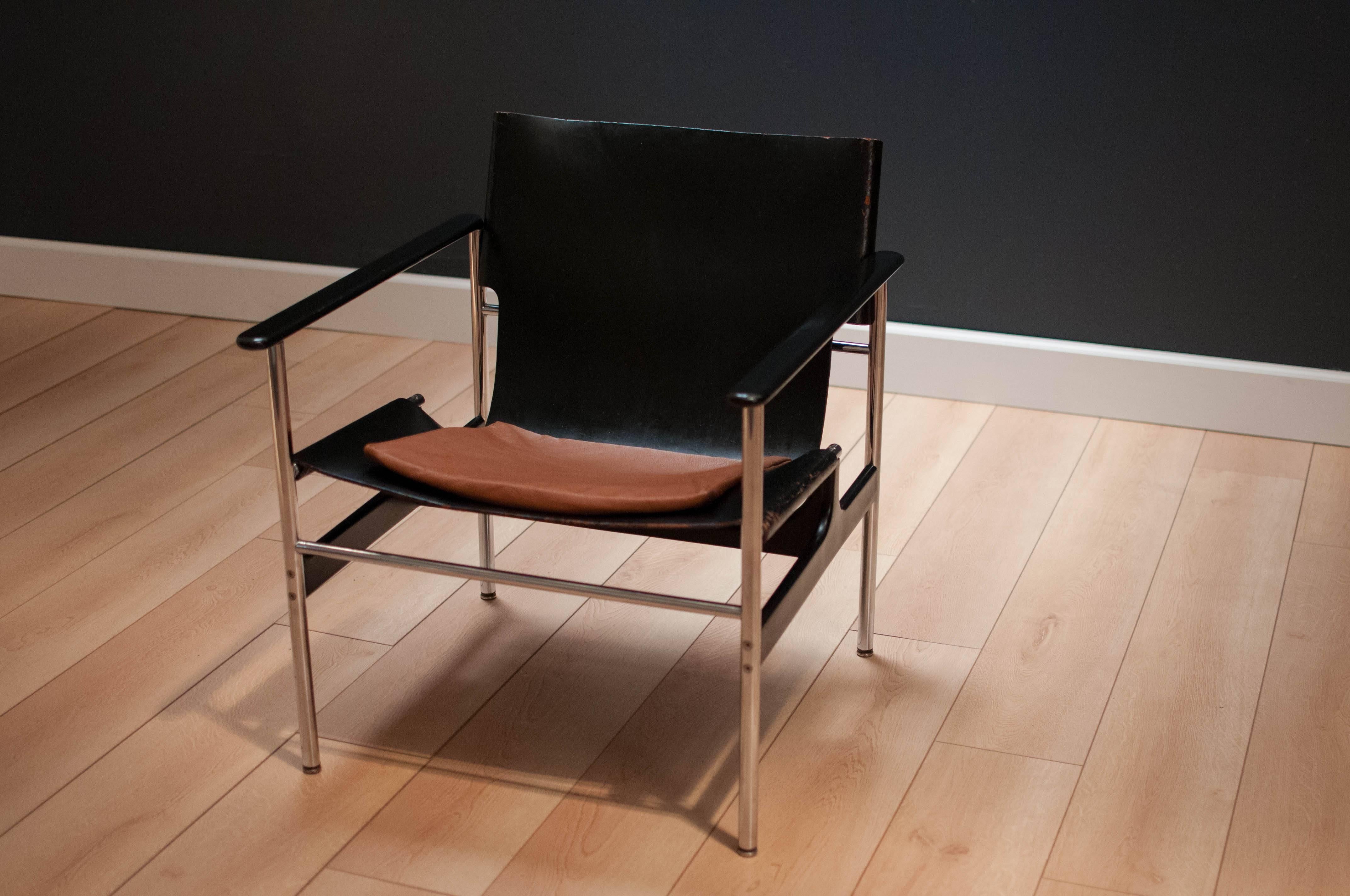 Vintage Knoll armchair 657 in cast aluminium and chrome finish. This iconic piece is designed by Charles Pollack and displays aged black leather with a tan leather cushion.

