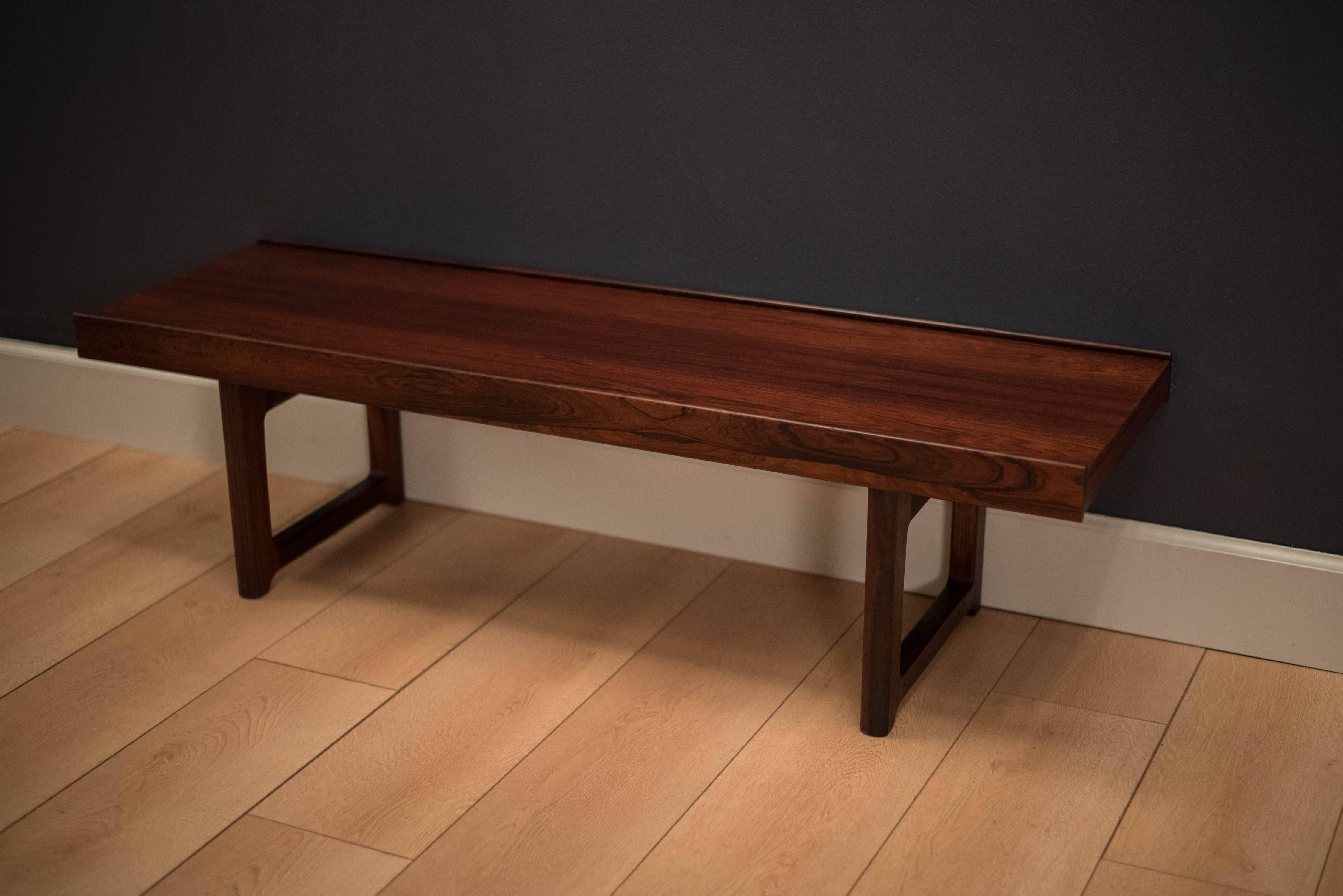 Torbjorn Afdal 'Korbo' bench or coffee table for Bruksbo made in Norway. This piece displays rich rosewood grain patterns and sculpted edges. Functions as a bench, coffee table or entryway piece.