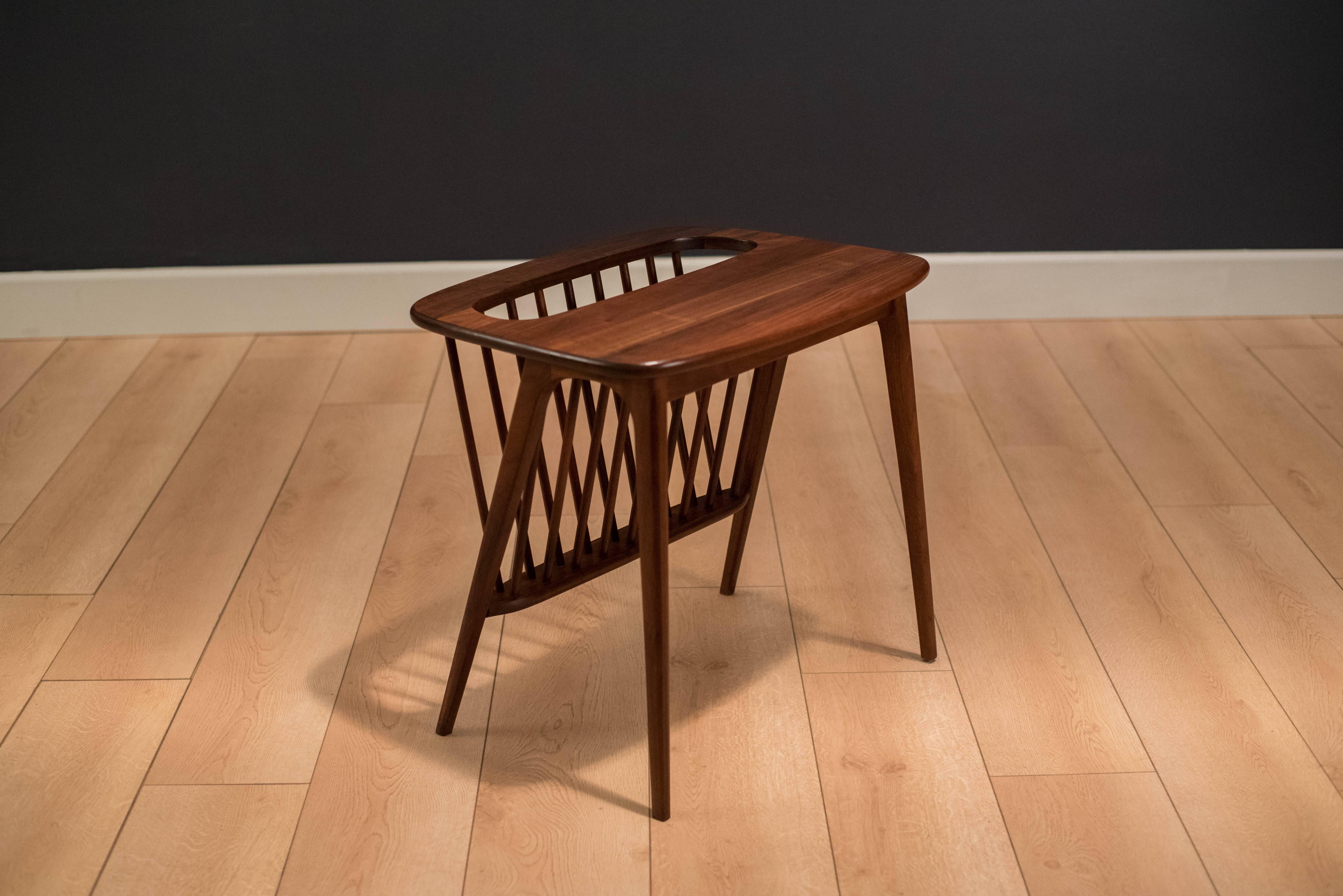 Mid-Century side table with attached magazine rack. This functional piece is designed by Arthur Umanoff and is made of solid walnut. 


  