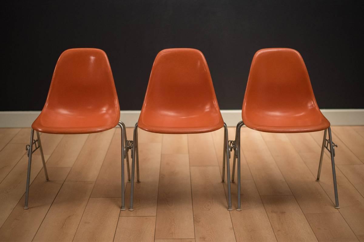 Mid-century Eames fiberglass stacking chairs manufactured by Herman Miller, circa 1960s. Three chairs are available in the original orange finish. Price is for each.



 