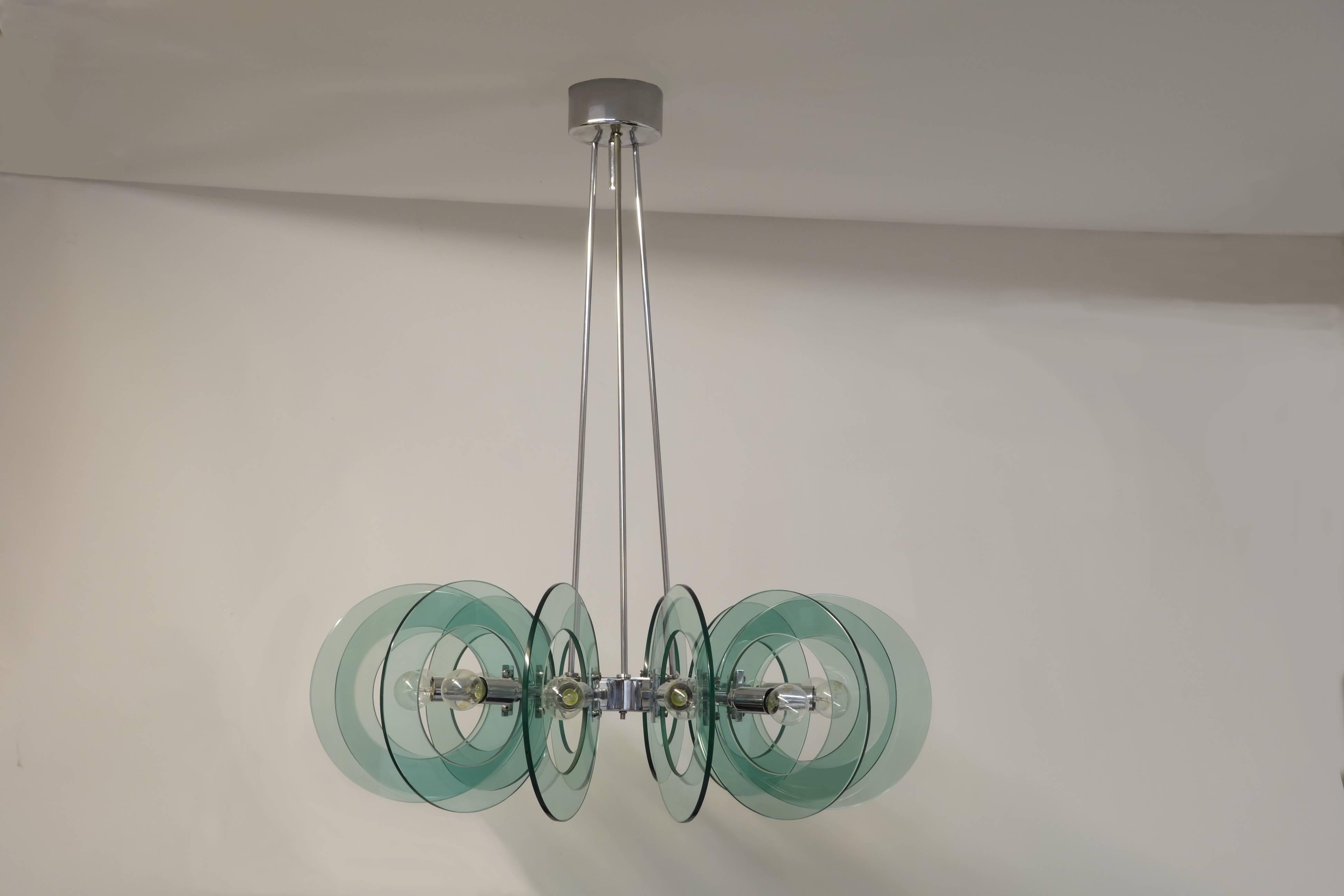 Stunning Fontana Arte chandelier equipped with its delicately Green/Blue shimmering glass discs mounted on a chromium frame including 12 bulb fittings. This very special object represents the understated elegance and style of Fontana Arte in an
