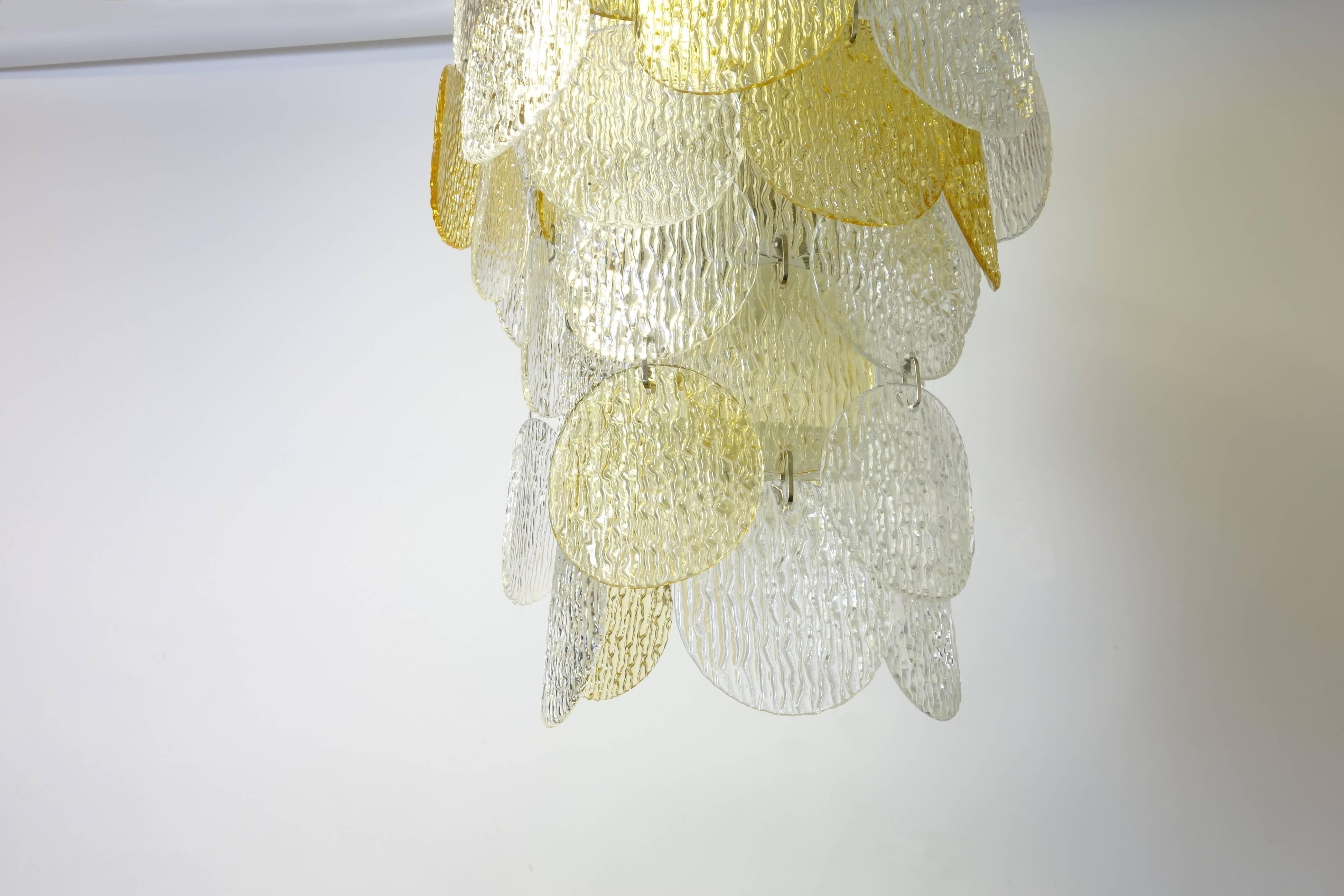 Beautiful Vistosi Torcello Murano chandelier with 26 textured glass discs in white and yellow; mounted on aluminium frame including six bulb fittings.