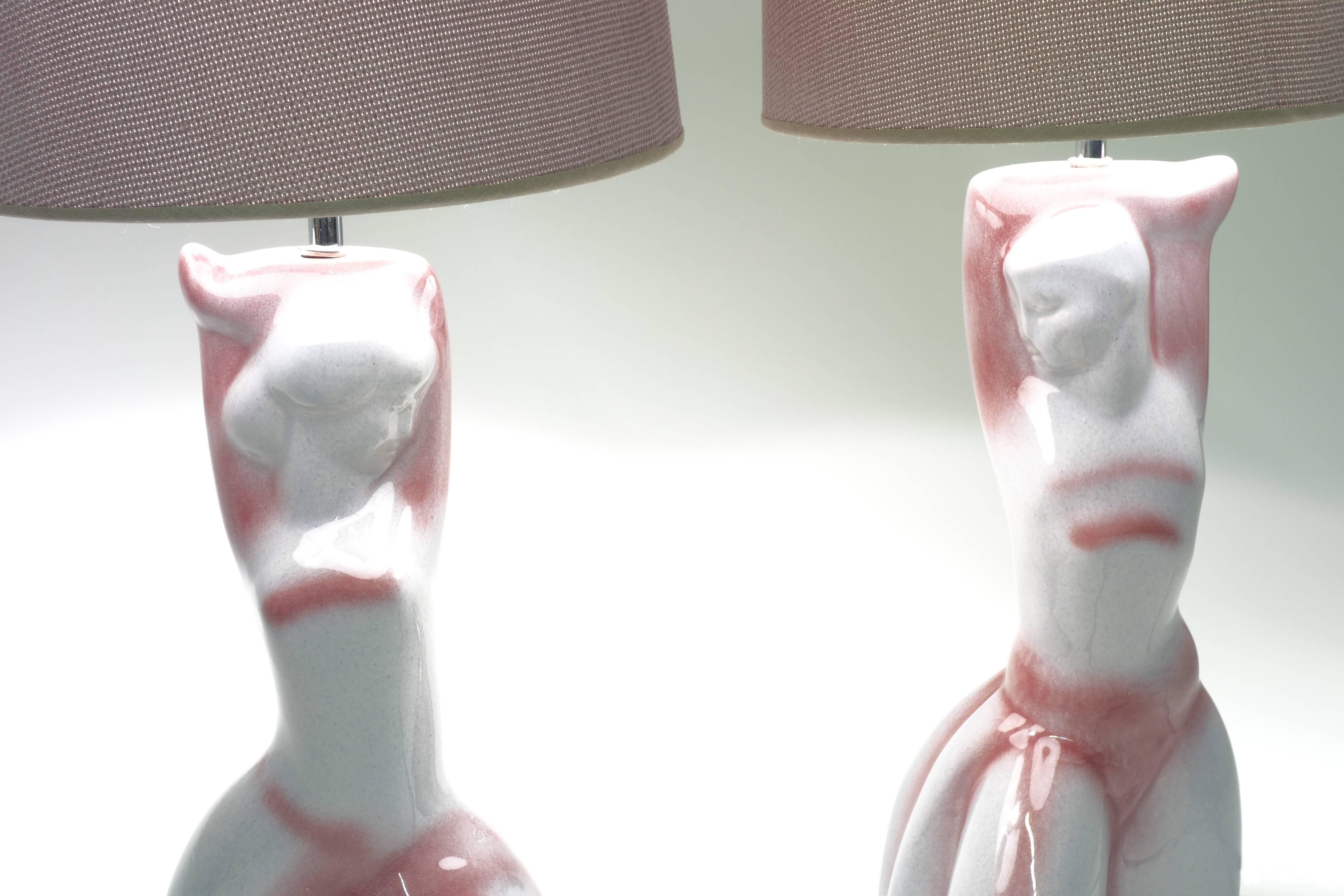 Table lamps made of two sculptures showing interacting couple, glazed ceramic with structured mauve textile shades.
