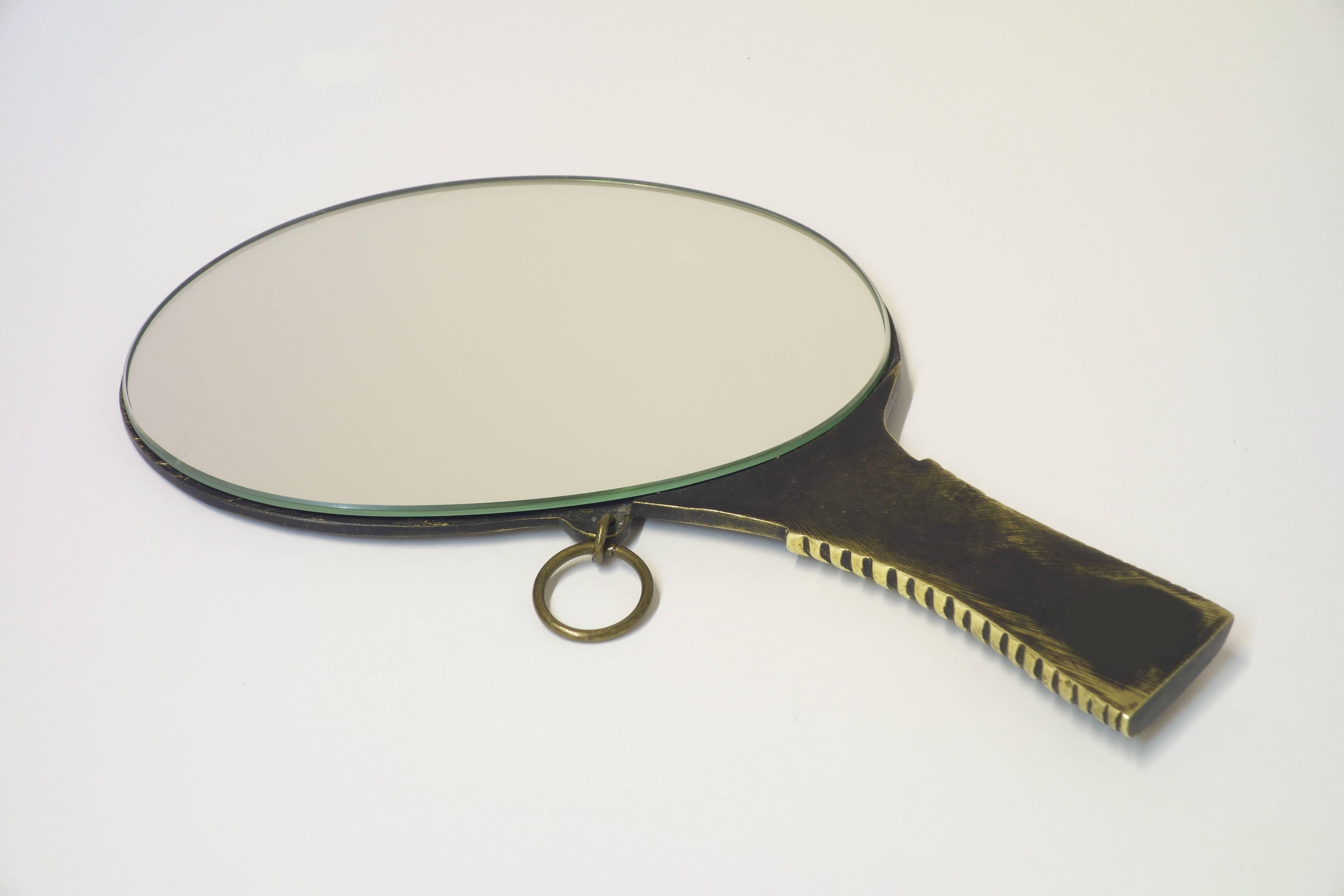 Extremely rare handmirror by Walter Bosse, design at arts level showing human presence on the mirror side and humans history on the backside. Solid brass partly blackened in excellent original condition.
