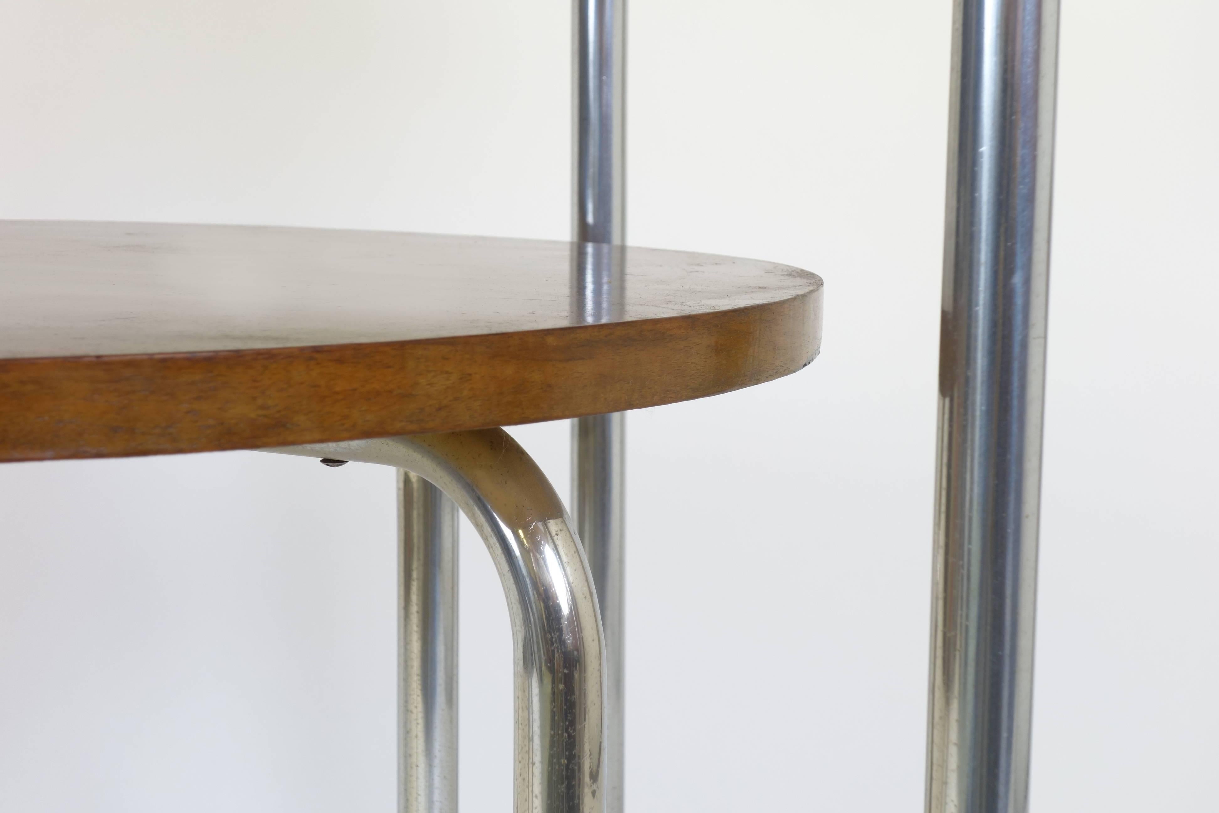 Eccentrically formed loop side table in the style of Bauhaus, Mauser, Breuer. Continuous steel frame accentuating its characteristic severe, though handsome shape. Two circular wood tops of beech wood are surmounting its classical and functional