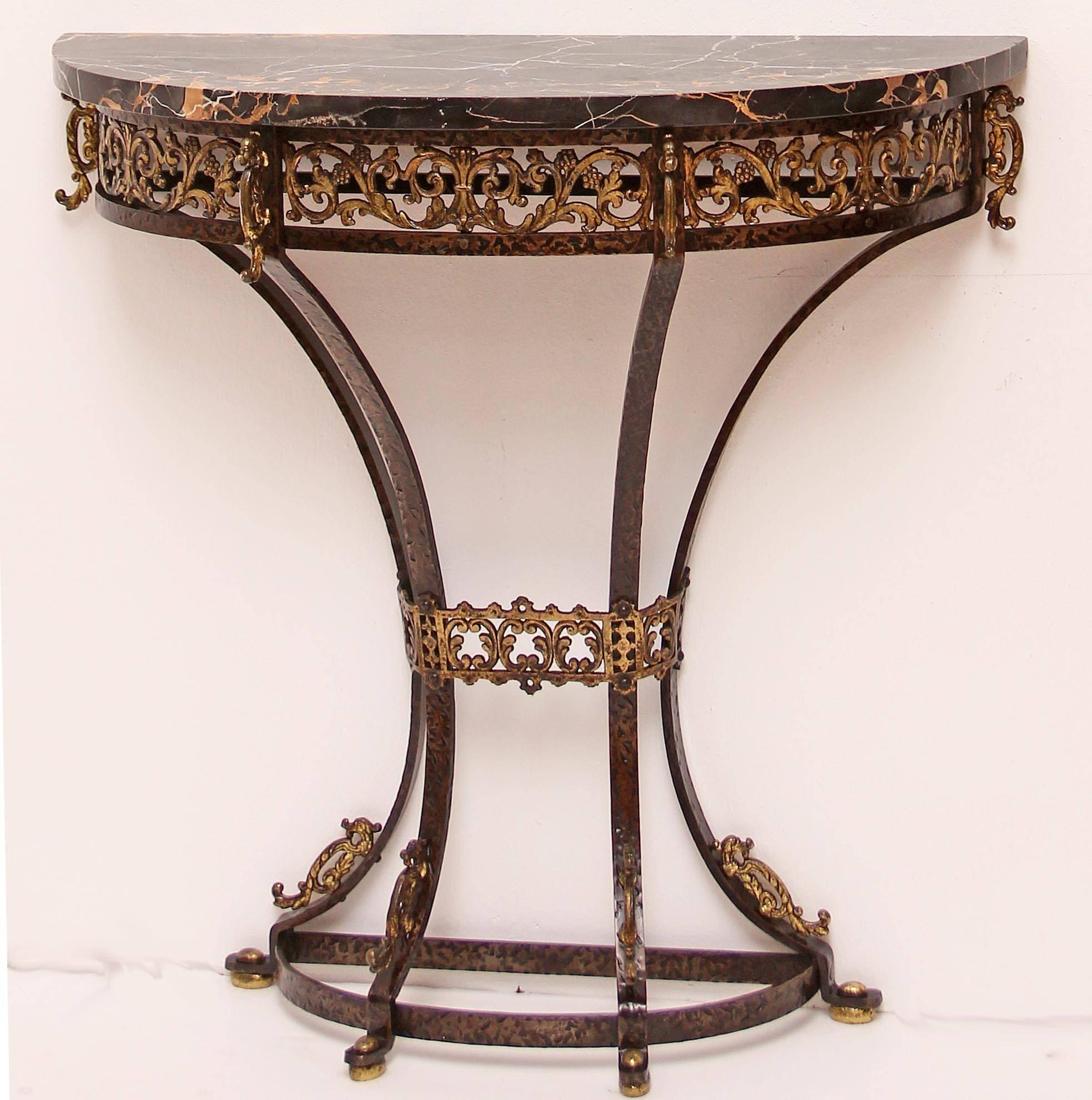 Antique hammered and gilt wrought iron console and mirror attributed to Oscar Bach. Figured black marble top.