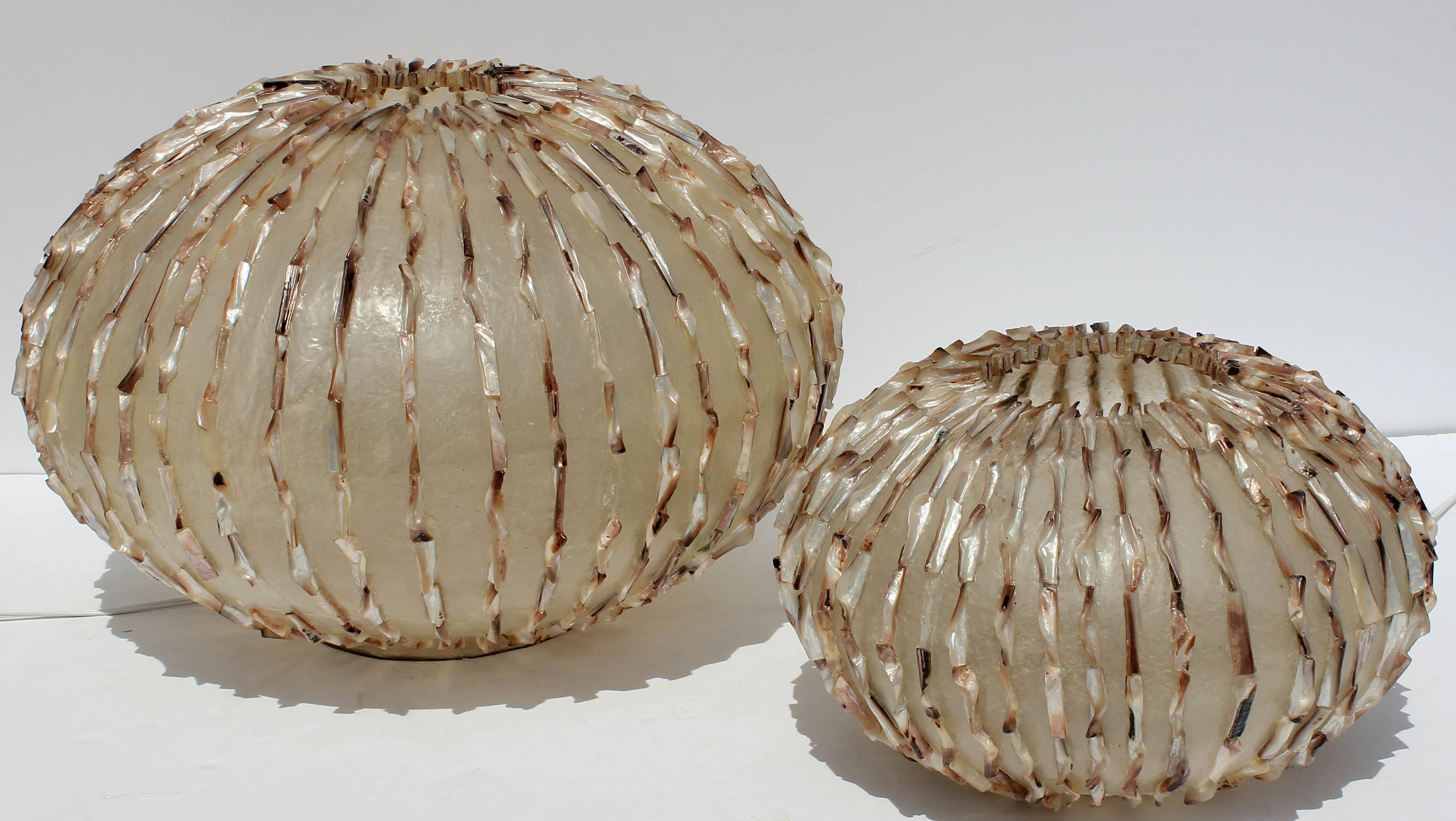 Two unique vintage Mid-Century Modern fiberglass and natural shell globe shaped table lamps. Larger measures 22" diameter and 15" high. Smaller measures 16" diameter and 10" high. They have the potential to be converted to
