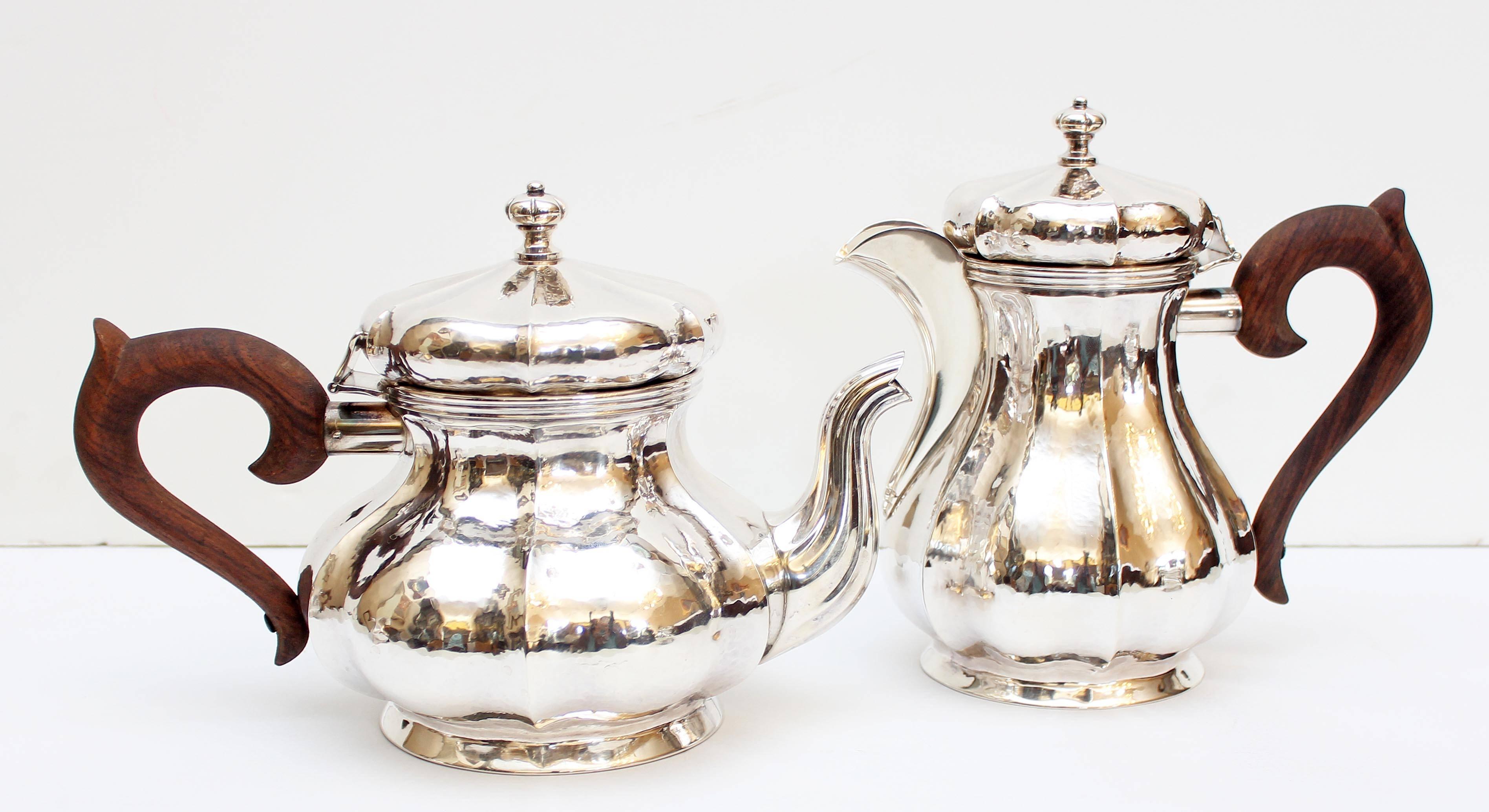 Sterling silver tea and coffee service. Each piece with hand-hammered lobed bodies and carved rosewood handles. Provenance: Estate of John Wehle former president of Genesee Brewery and founder of Genesee Wildlife Museum. Buccellati is an Italian