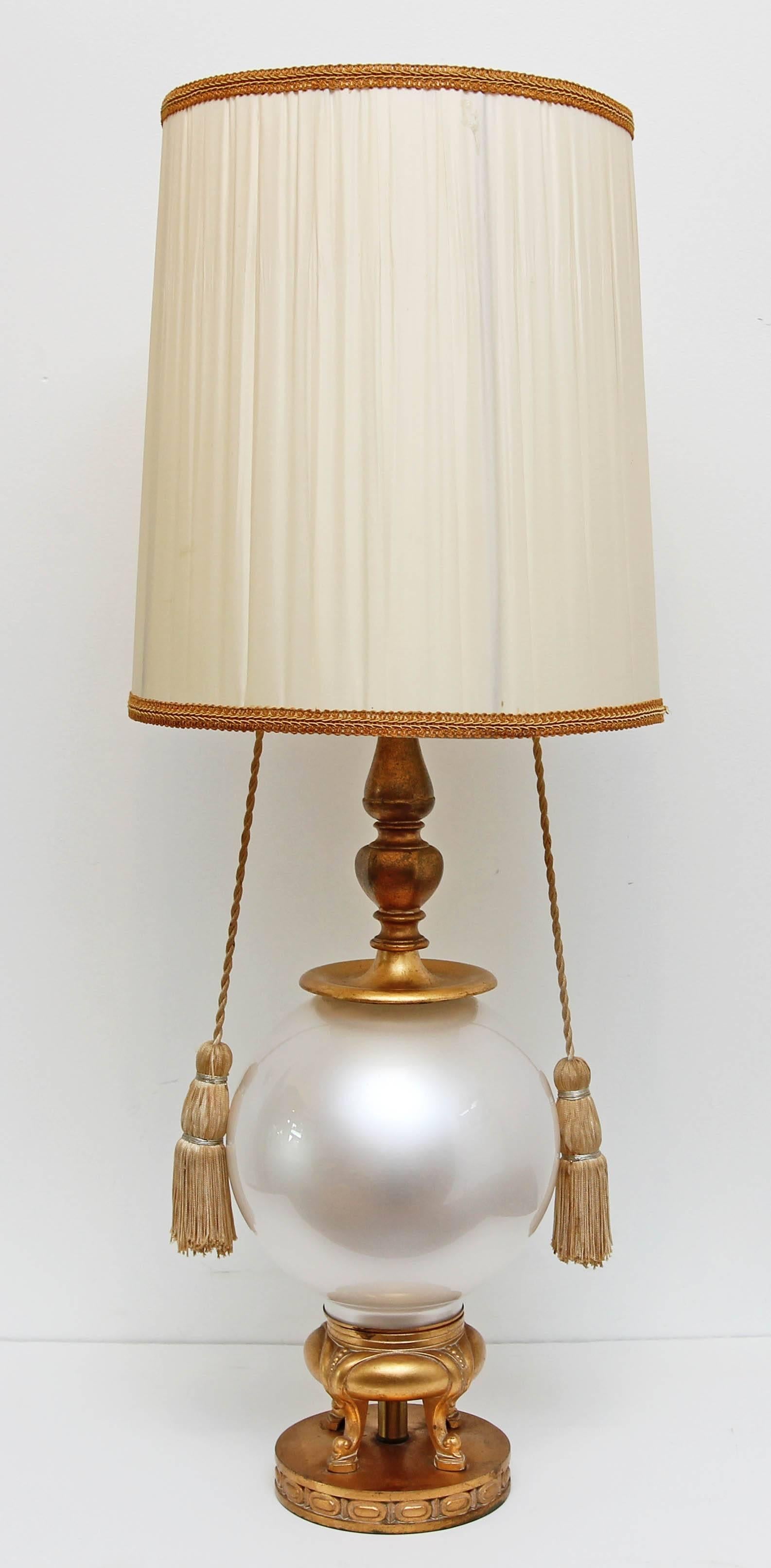 Vintage hollywood regency lamp by Marbro. Opaline glass globe base with gold gilt metal mounts. Original silk tassel pulls. No shade.