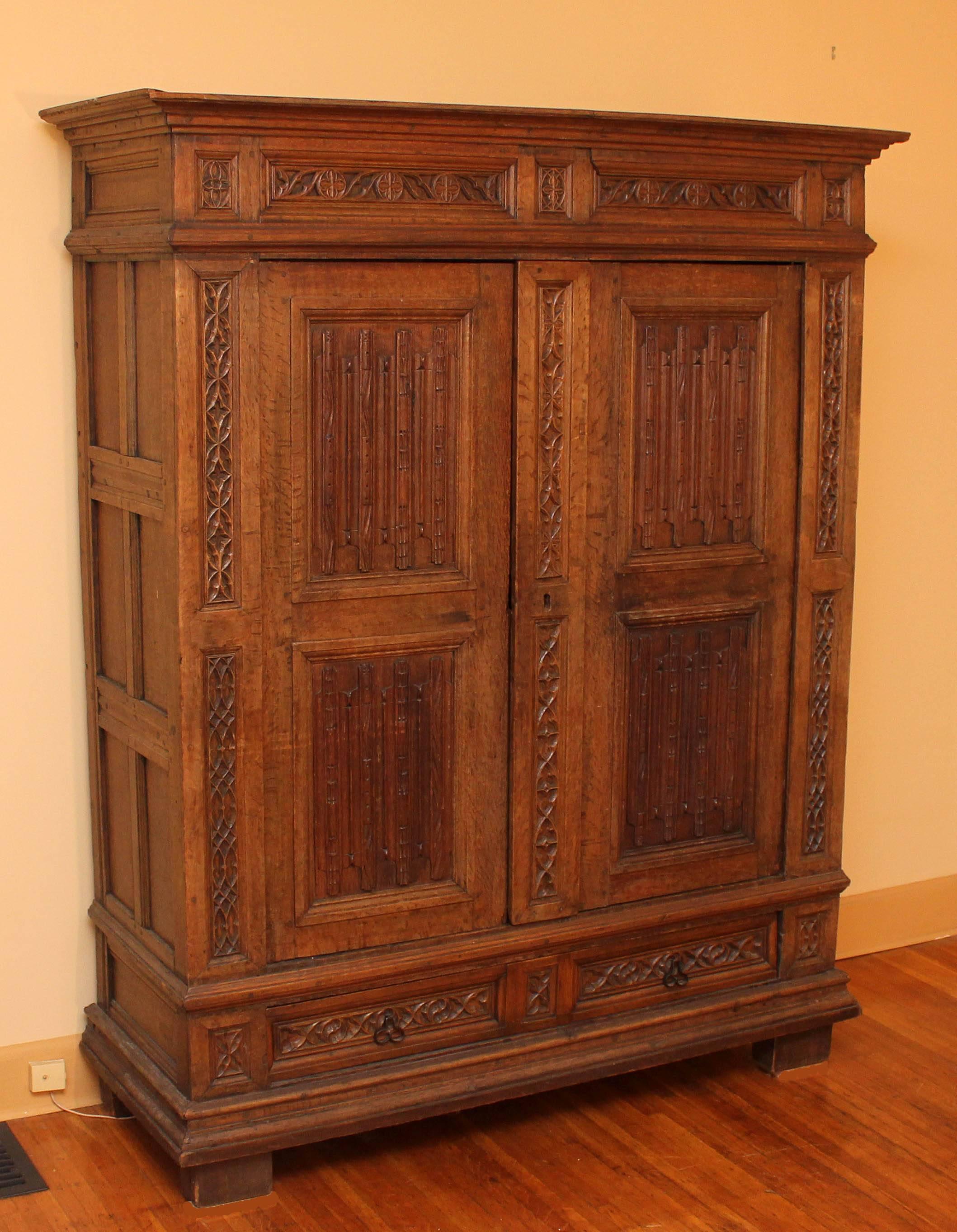French antique Gothic armoire, Finely carved quarter sawn white oak. Two doors over one large drawer. Interior fitted with shelves. Original hand tooled locking device. Mortise and tenon joinery and constructed of 1 1/4