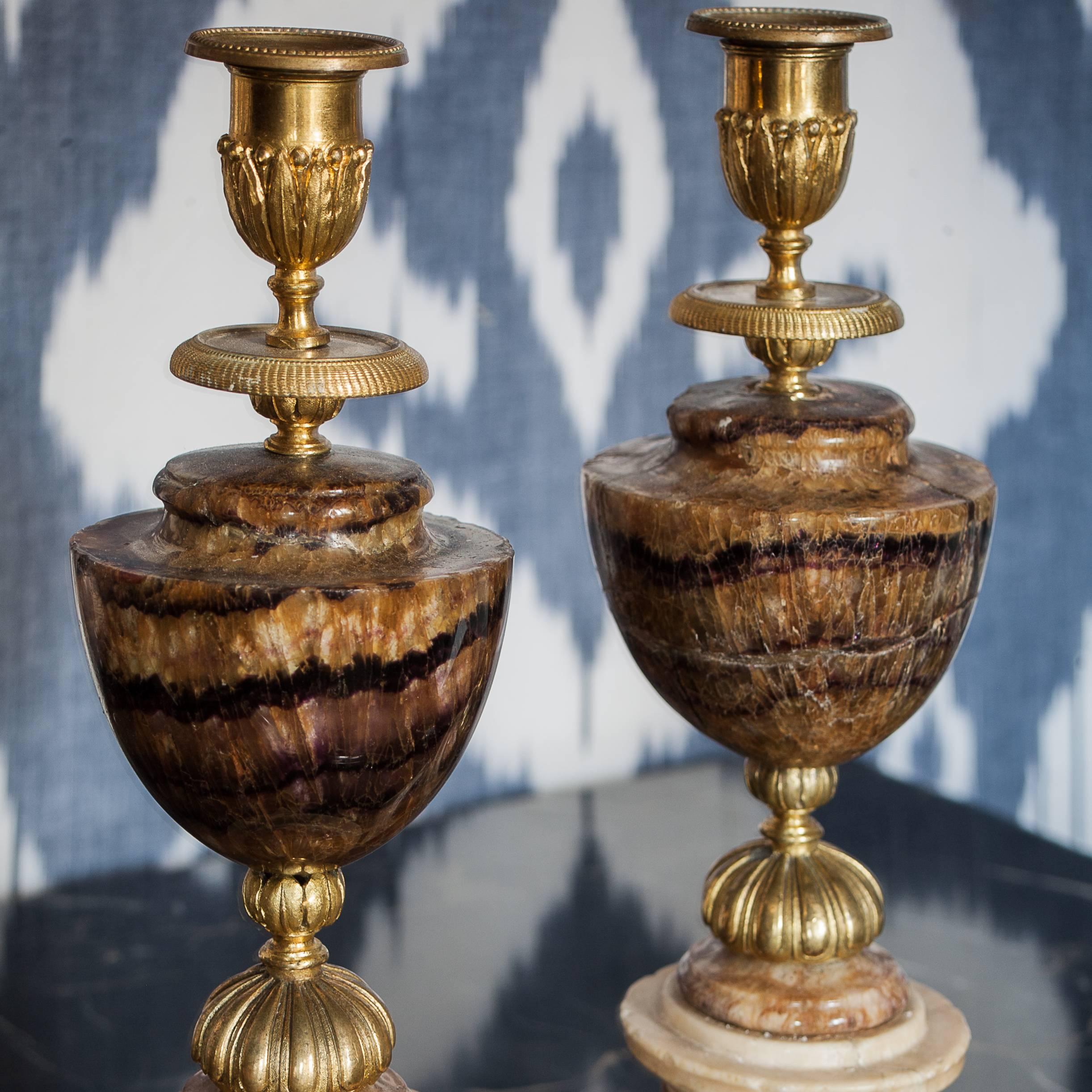 A pair of late 18th century Blue John candlesticks.
 
The form of the candlesticks is dominated by the urn shaped Blue John in the centre of each.
 
The superb quality of the ormolu mounts feature a cup decorated with laurel leaves and berries,