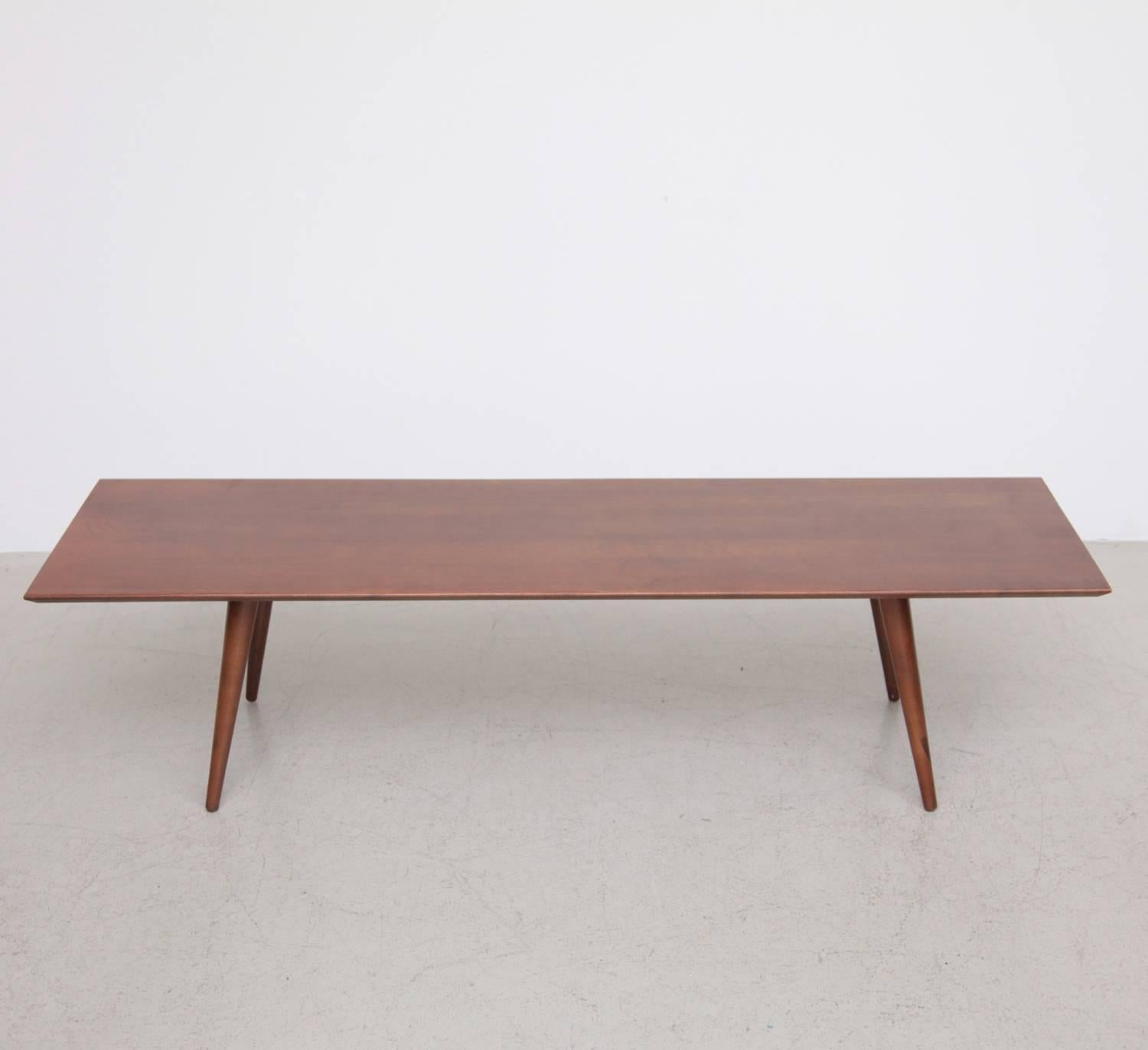 Planner Group coffee table designed by Paul McCobb which was his most well received furniture line during his long career. This example is an all original tobacco stained solid maple construction coffee table or bench with slender tapered legs, foil