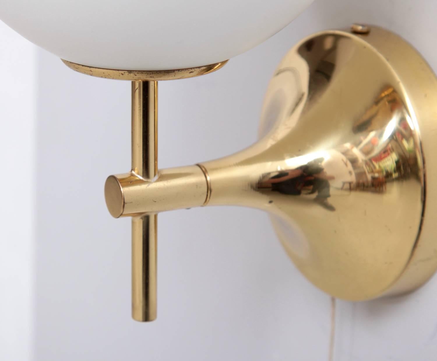 Pair of sconces composed of polished brass golden fixtures with white frosted glass globe shades in excellent condition. Signed! One x E14 each.
To be on the safe side, the lamp should be checked locally by a specialist concerning local
