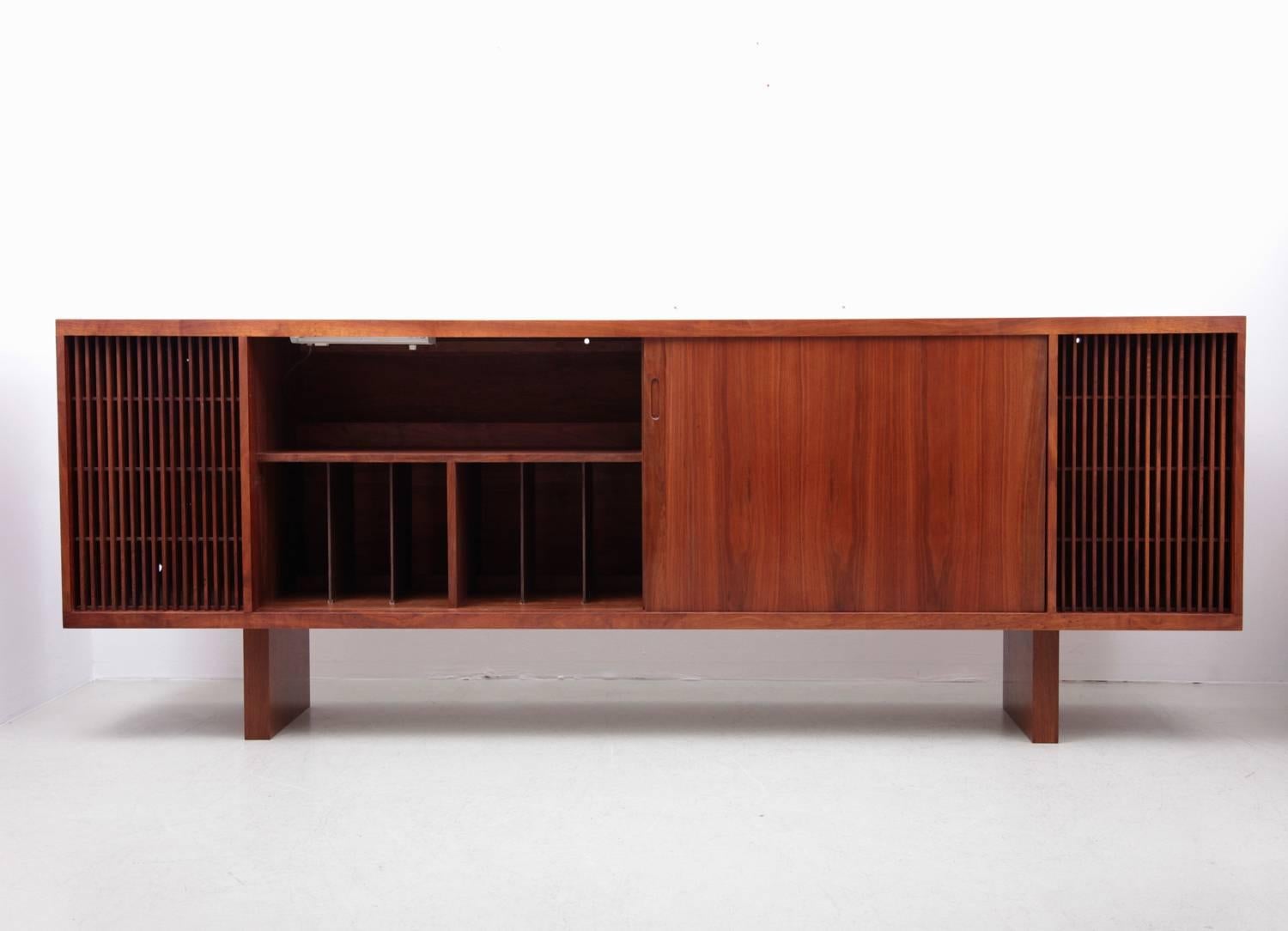 This cabinet is made in one piece and the quality is extraordinary. The left and right wooden slats part is to hide speakers. You can fill the center parts with records and Hifi. An amazing sideboard for every music lover.

