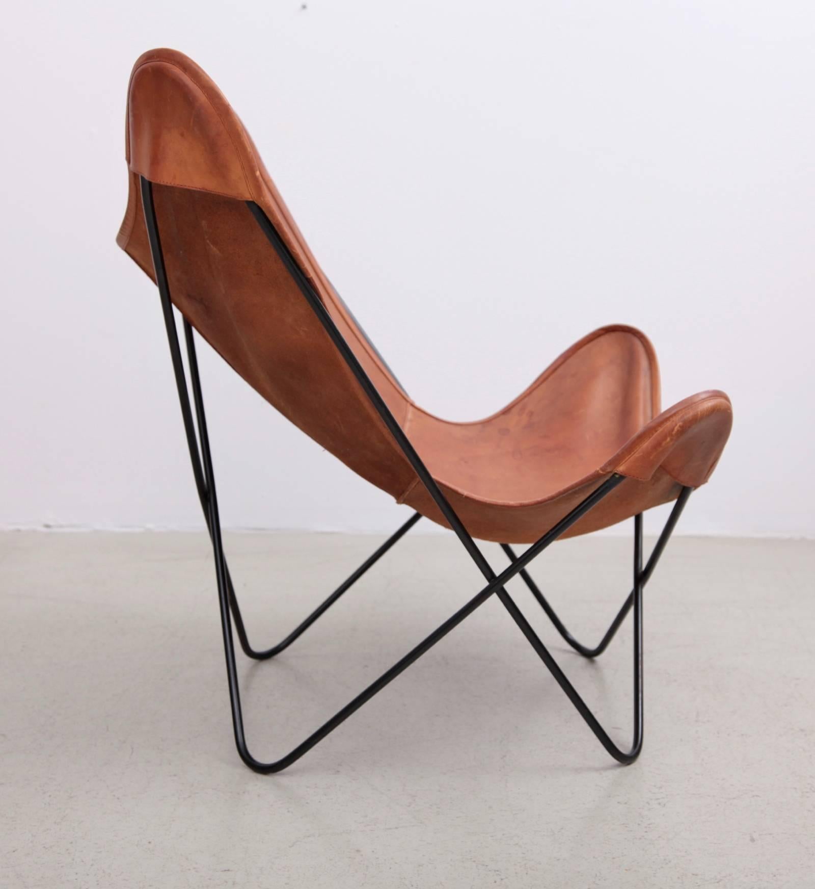 Butterfly chair by Knoll International with exceptionally beautiful original leather in cognac on a black base. Designed by J. Ferrari-Hardoy, J. Kurchan, A. Bonet in 1938. Manufactured from 1947-1975 by Knoll International. The center has a