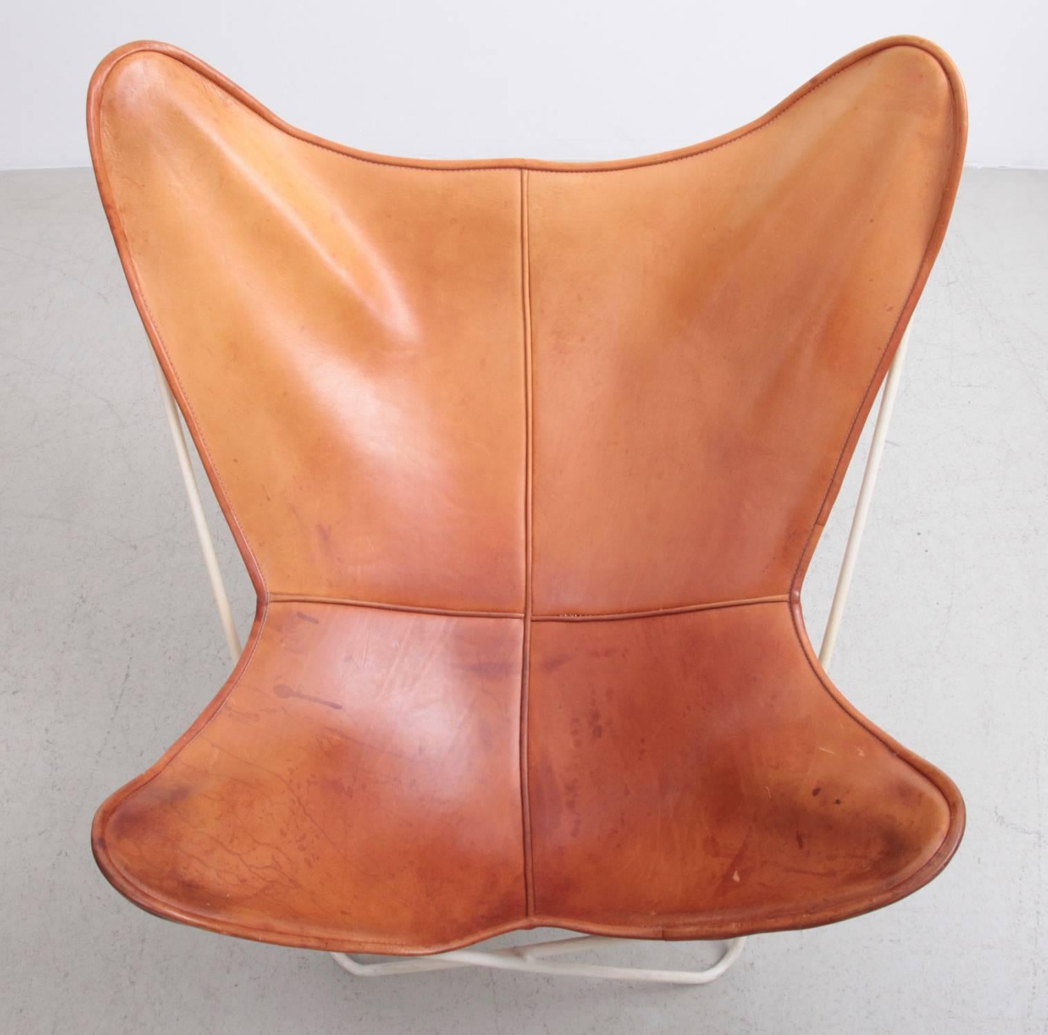 Butterfly chair by Knoll International with exceptionally beautiful original leather in cognac on a white base. Designed by J. Ferrari-Hardoy, J. Kurchan, A. Bonet in 1938. Manufactured from 1947-1975 by Knoll International. An absolute authentic