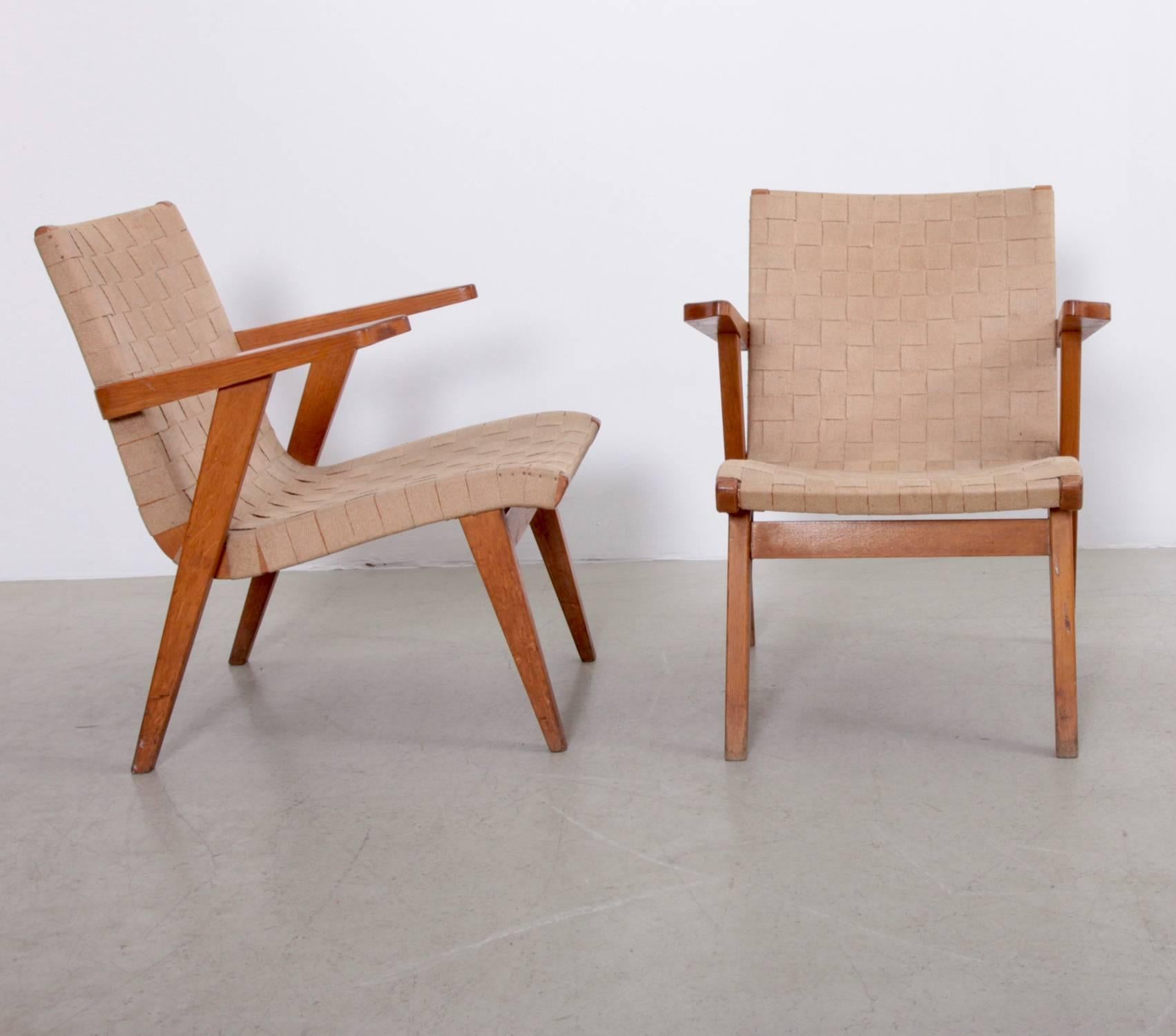 Rare pair of Jens Risom lounge chairs with arm rests by Knoll, France.
Knoll produced the Risom Furniture only in France with oak. The webbing is an older reupholstery but very well done with a natural canvas webbing.

