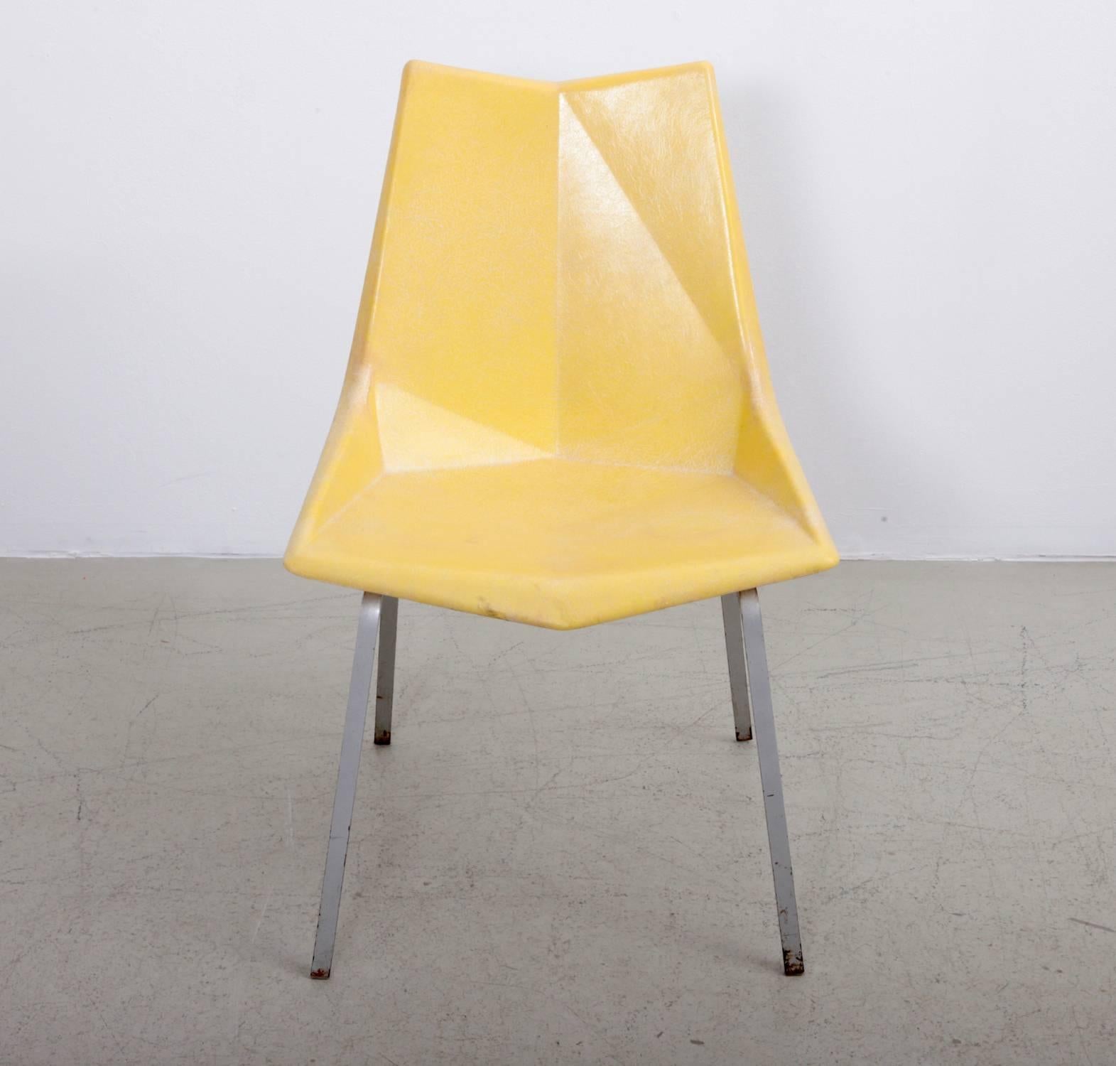 A 1950s yellow Paul McCobb Origami chair for St. John seating. The fiberglass seat is molded at angles, reminiscent of the Japanese origami technique. The chair stands on a rare angled solid iron base. In good and original condition.

