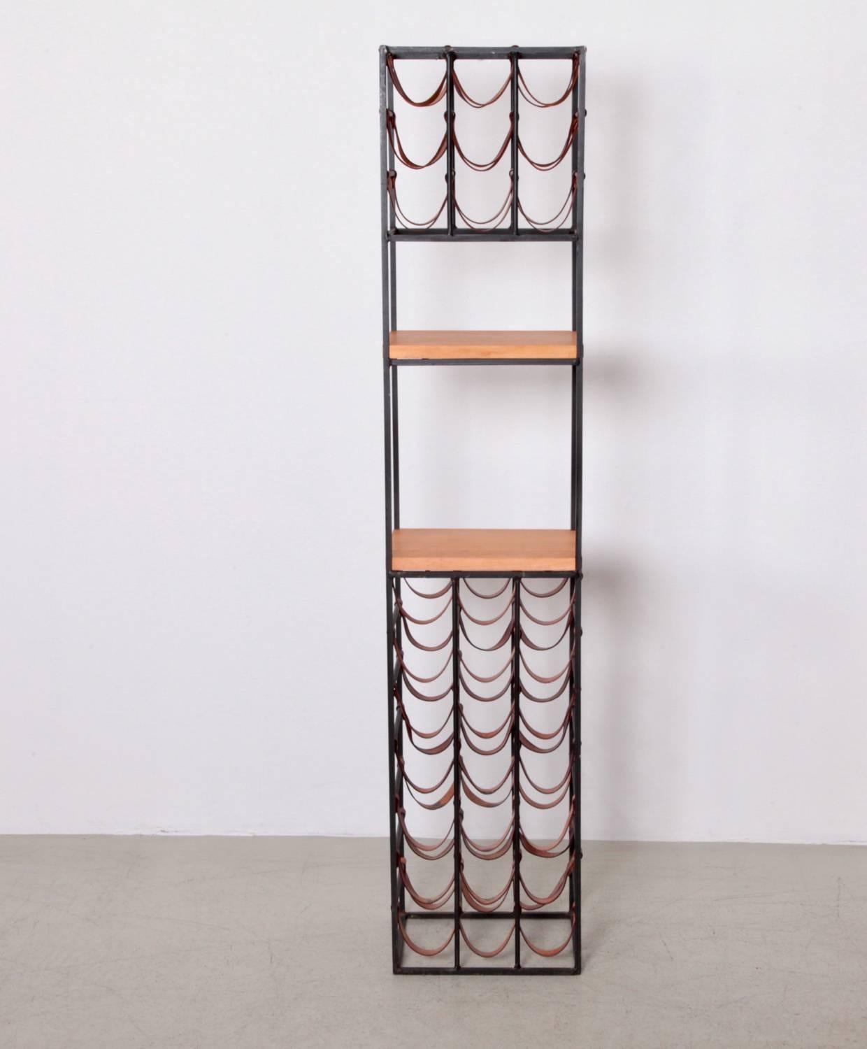 Large tower wine racks by Arthur Umanoff, made of wrought iron with leather straps, two butcher block shelves for cutting or display, holds 30 bottles.