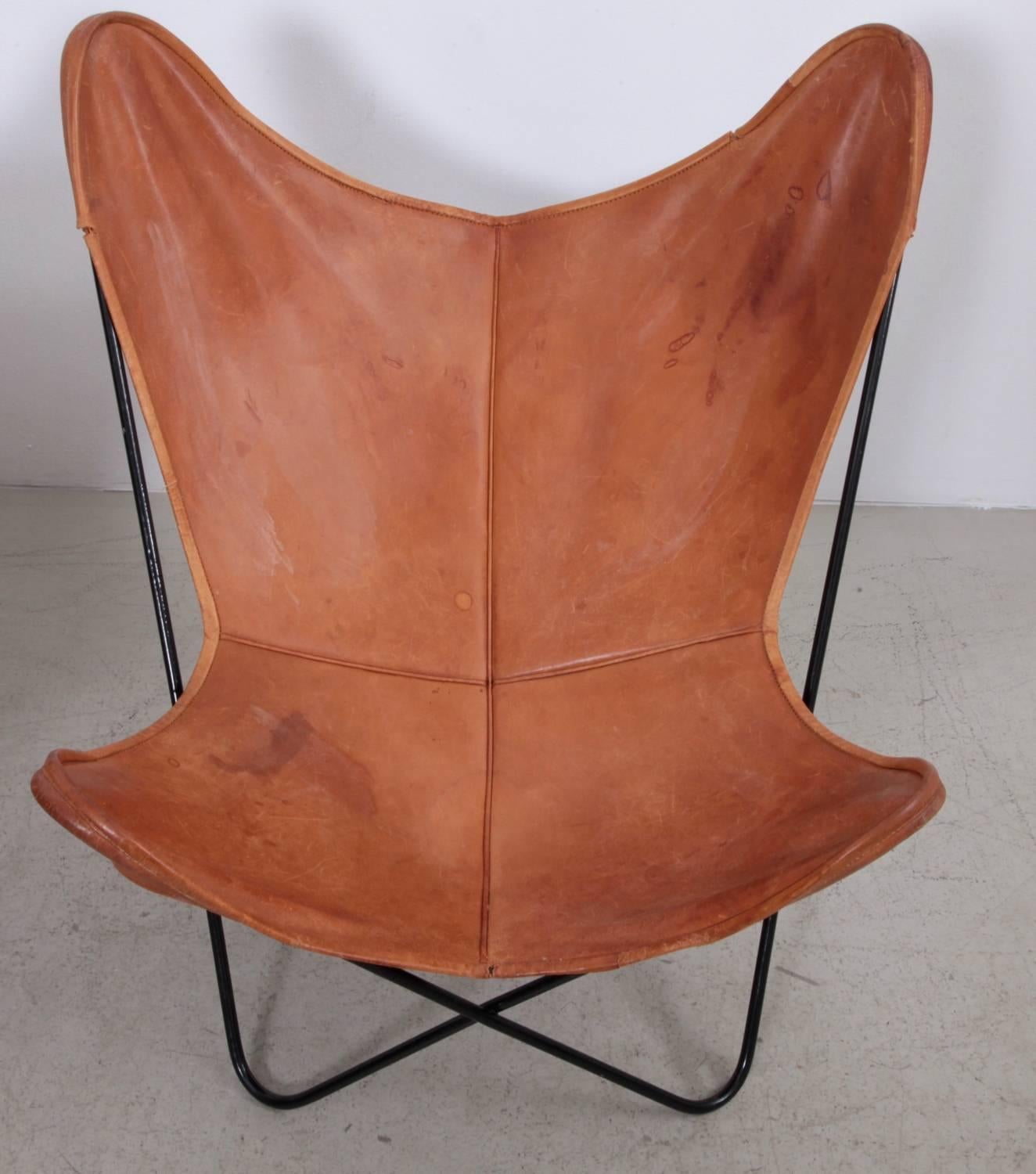Butterfly chair pair by Knoll International with exceptionally beautiful original leather in cognac on a black base. Designed by J. Ferrari-Hardoy, J. Kurchan, A. Bonet in 1938. Manufactured from 1947-1975 by Knoll International. The chairs have