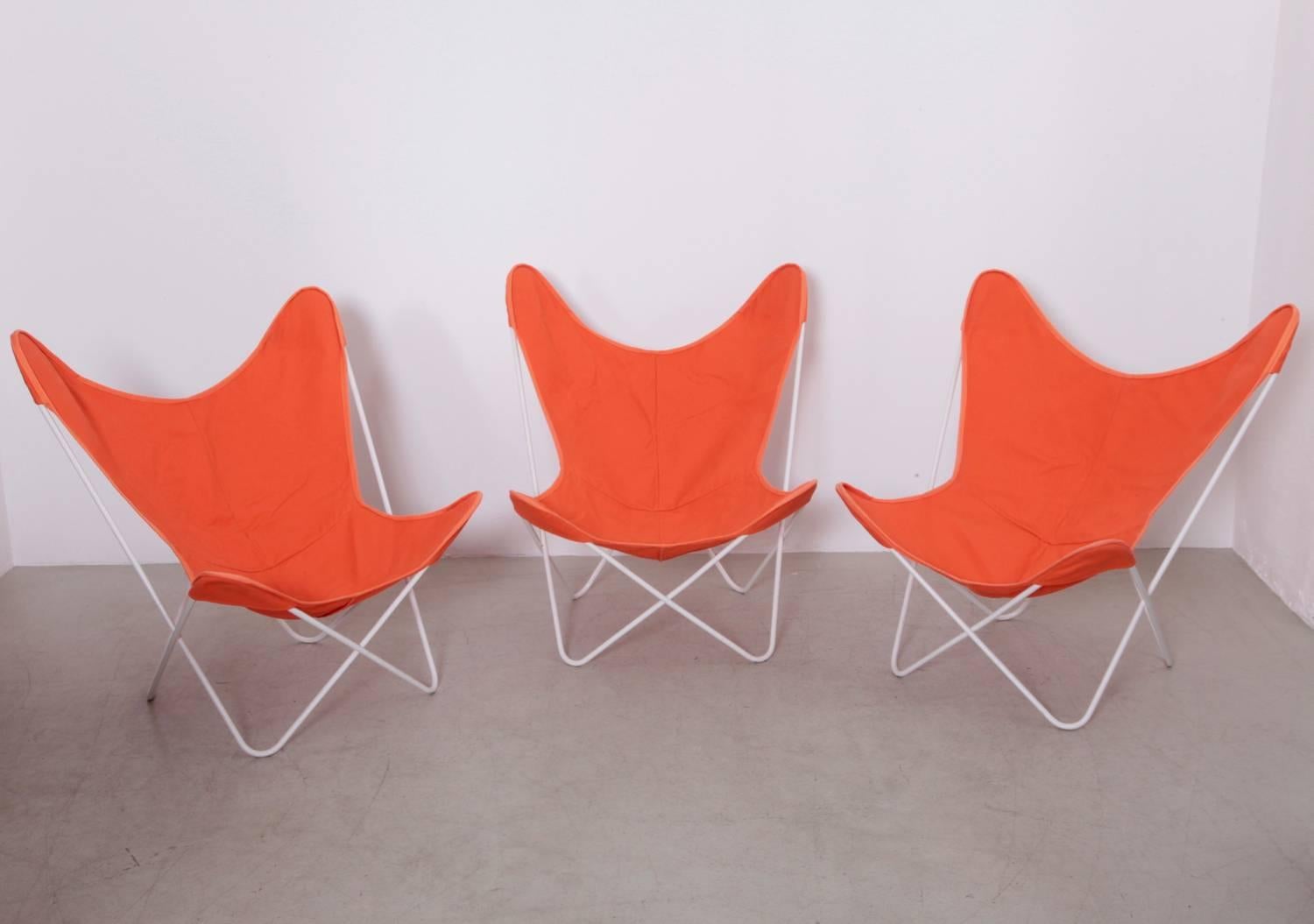 Old iron frames with orange cloth sling seat covers. Clean and room ready, circa 1958.