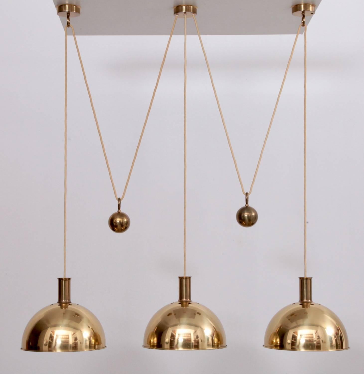 Really beautiful Florian Schulz triple posa pendant lamp with 1 x E 27 / model A bulb in each polished brass shade.