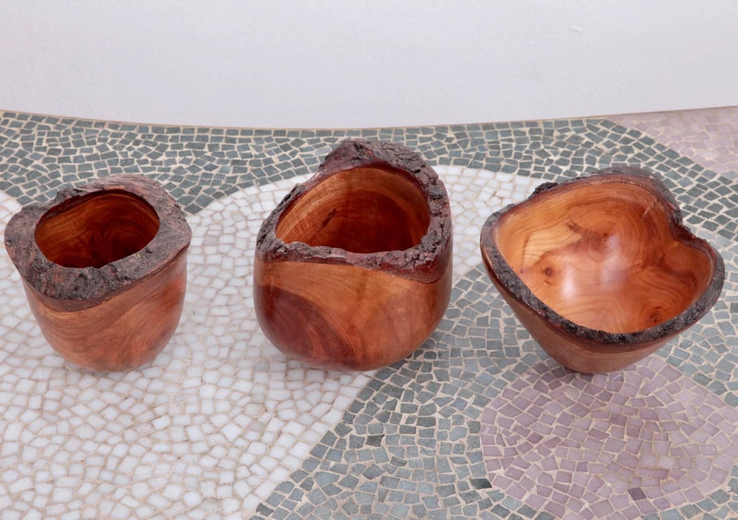 Set of three turned cheerywood bowls with natural bark.

