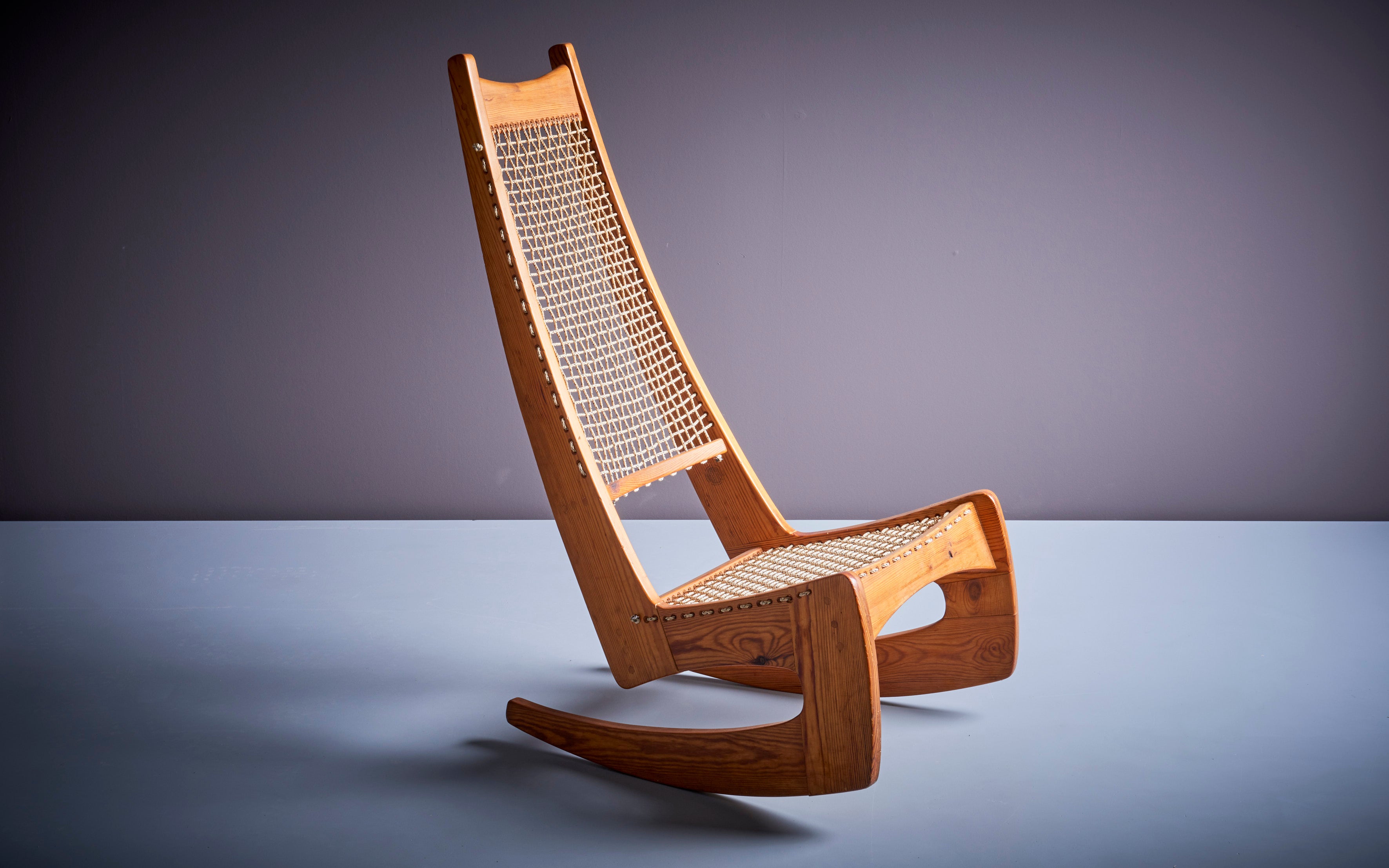 Jeremy Broun 1970er Studio Schaukelstuhl mit Tennisnetz Sitz und Rückenlehne. Der Stuhl ist aus Kiefernholz gefertigt und in sehr gutem Zustand.