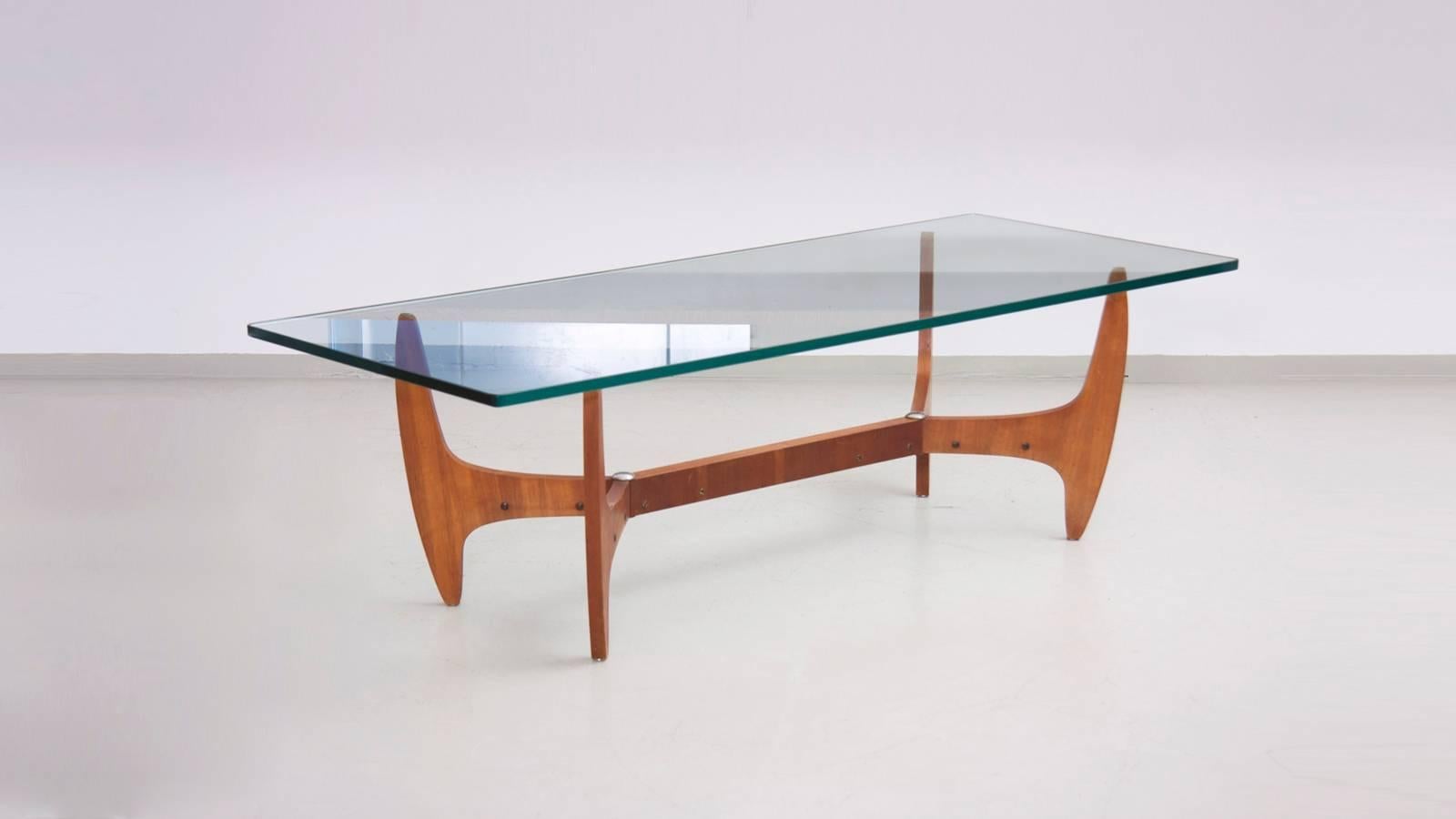 Highly decorative midcentury coffee table with heavy and thick glass top. The base is produced in beautiful grainy wood with metal details, in fantastic condition.

