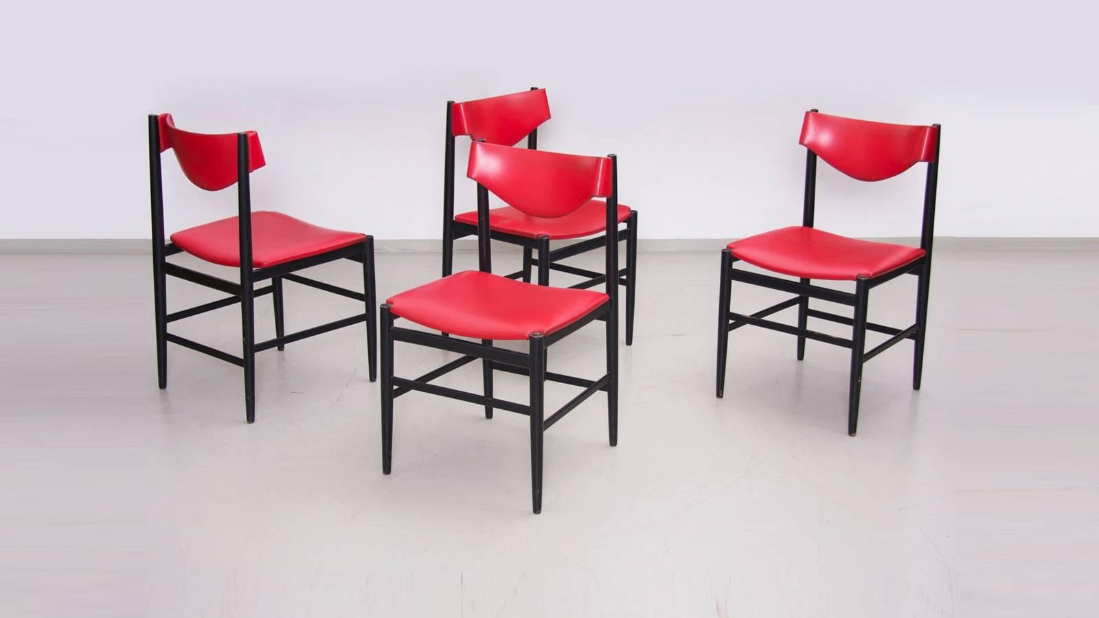 Rare vintage set of four chairs by Gianfranco Frattini for Cassina. Marvellous round shape of the back rest, fully covered in red artificial leather. Lacquered black frame really close to Leggera and Superleggera proportions.

