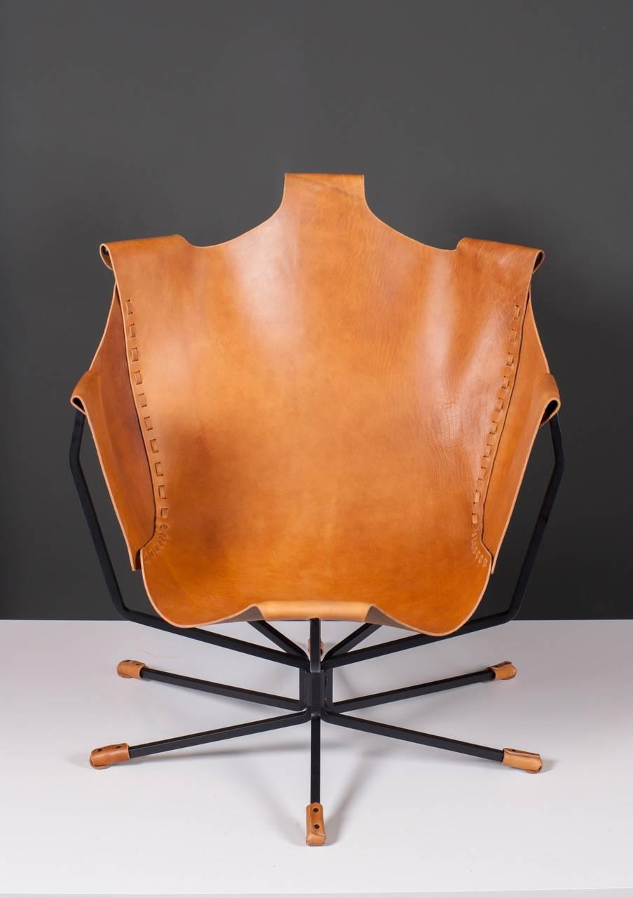 Lounge chair made of latigo leather on a black steel base. A very comfy and rich chair.

