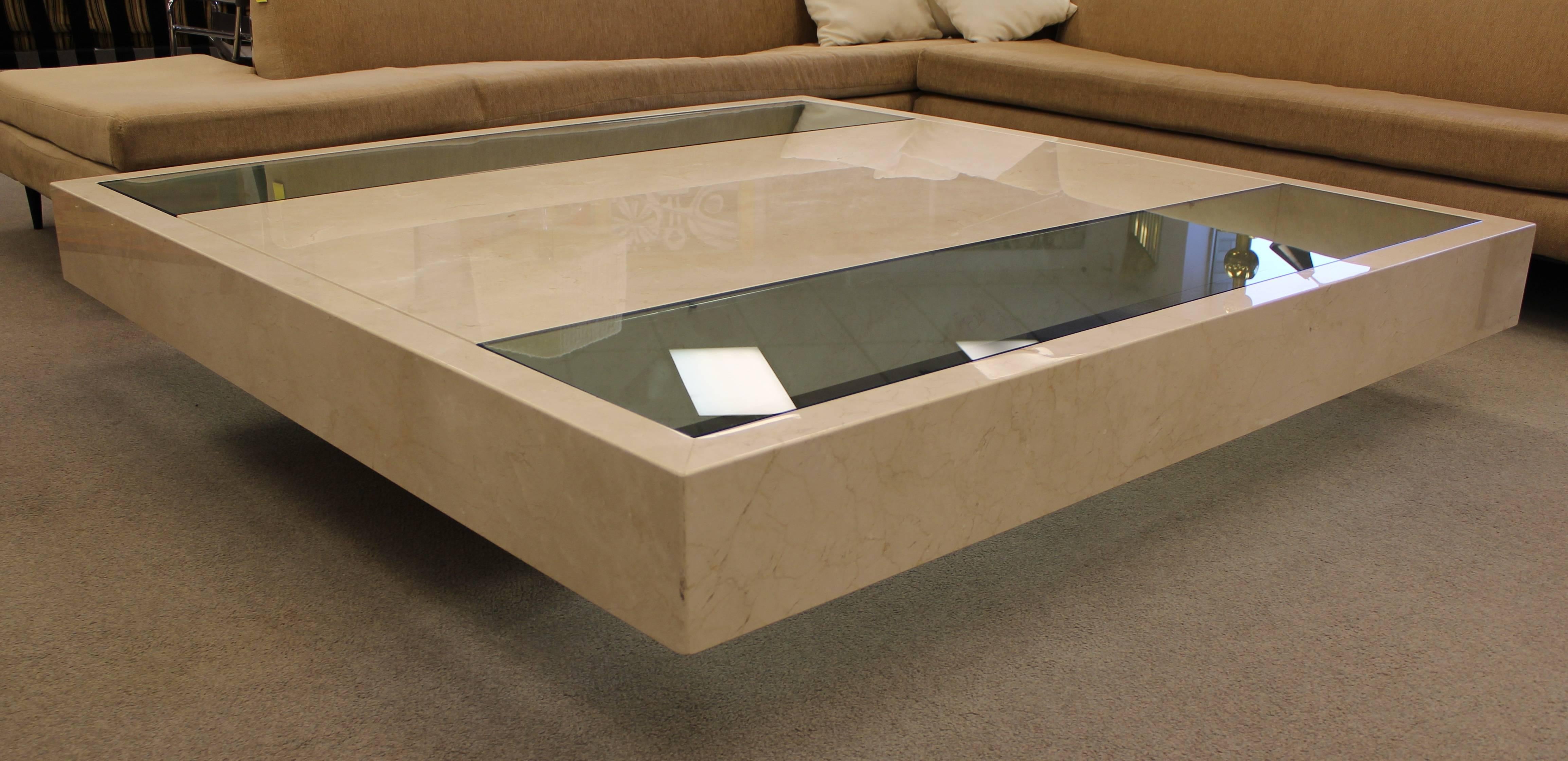 Monumental floating marble and glass coffee table that is sitting atop a marble base. Glass has been custom cut for the table and is 3/4