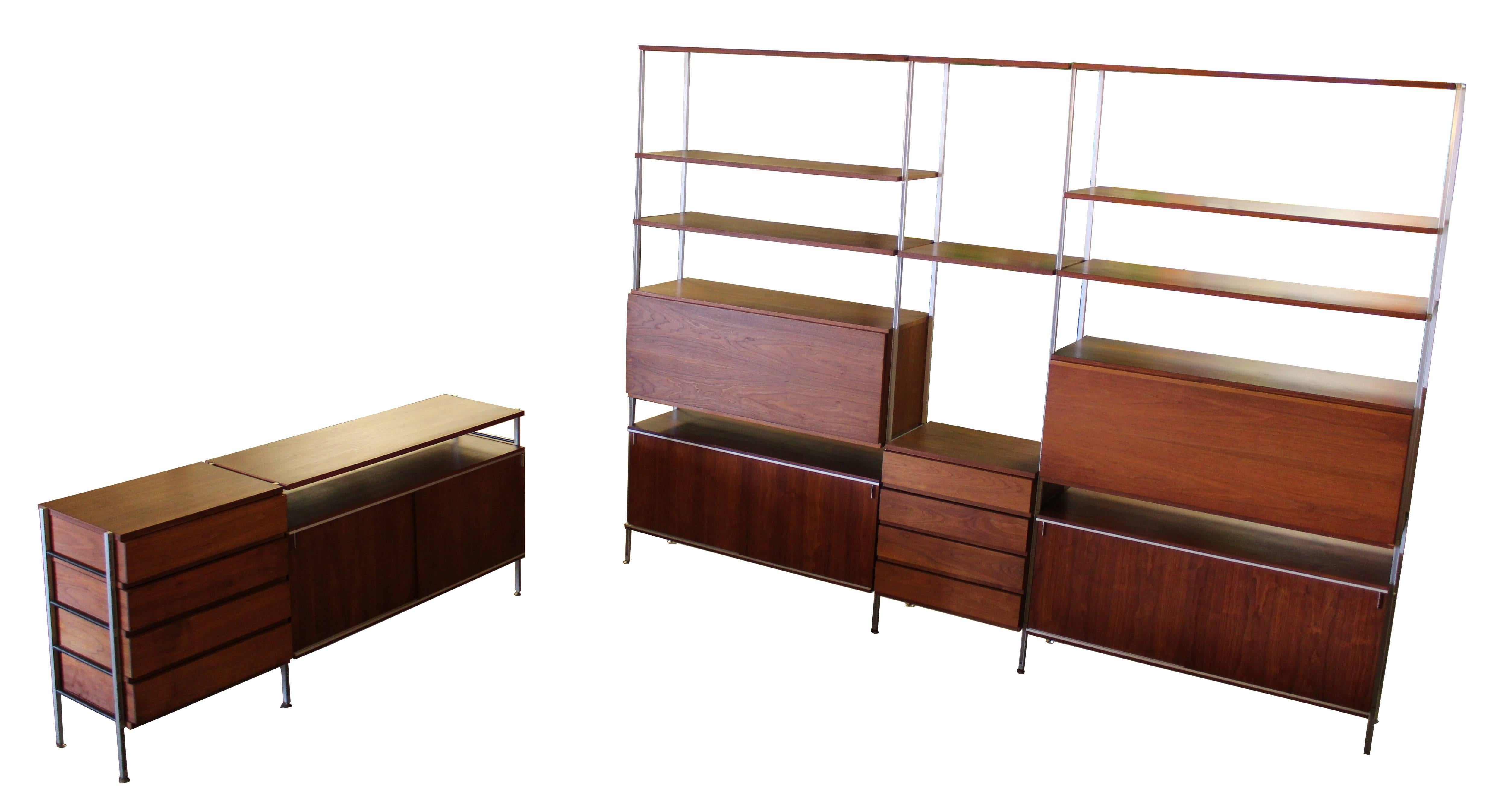 
Inredible, very large, walnut wall unit and matching credenza by Hugh Acton. Wall unit has compartmentalized pull down desk space with a light. Retains an original metal plaque. The dimensions of the wall unit are 113.5
